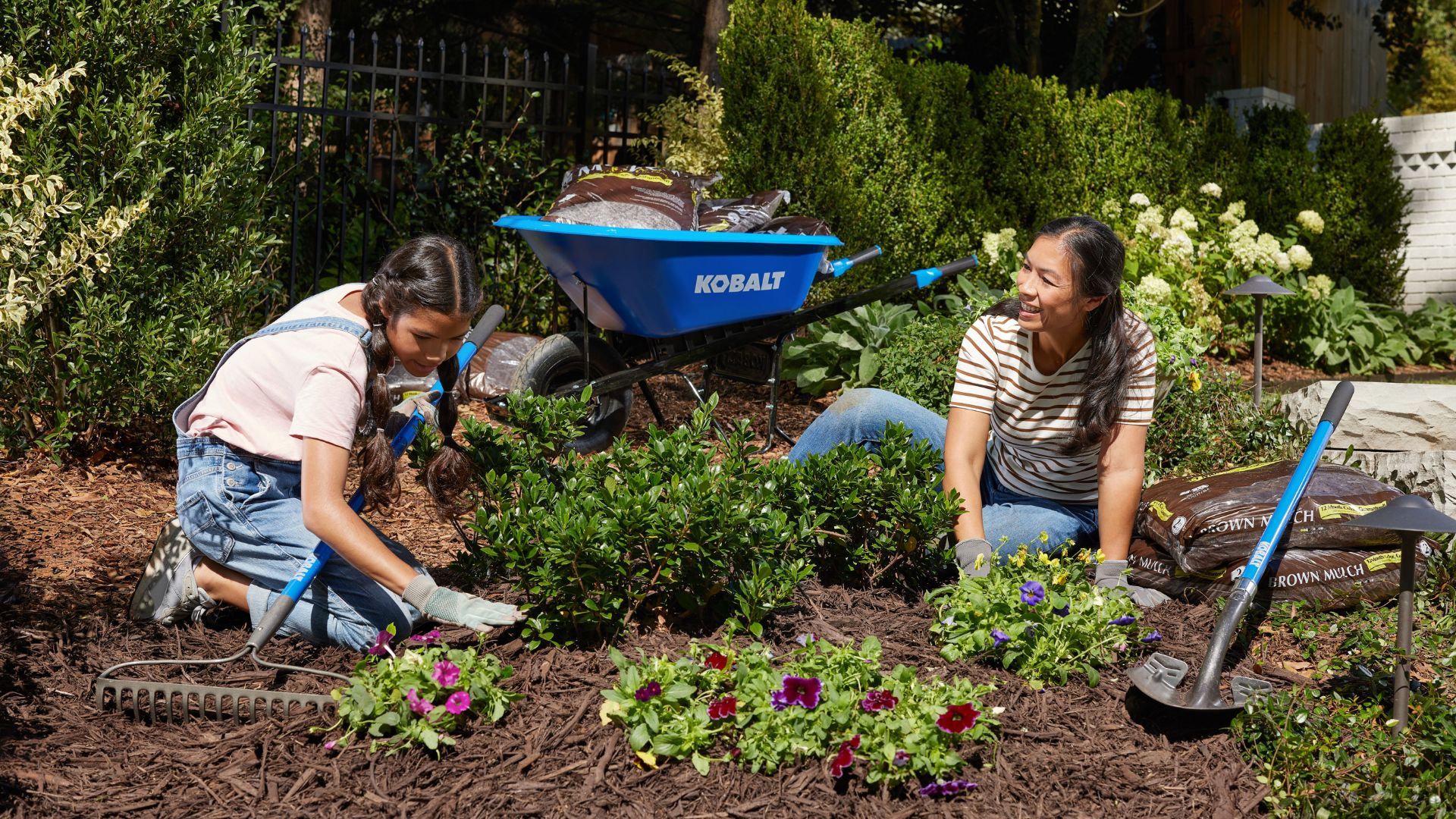 Two woman mulching in the front yard.
