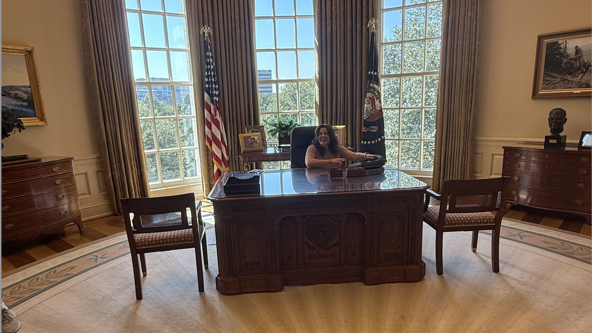 A woman sitting at a desk and laughing 