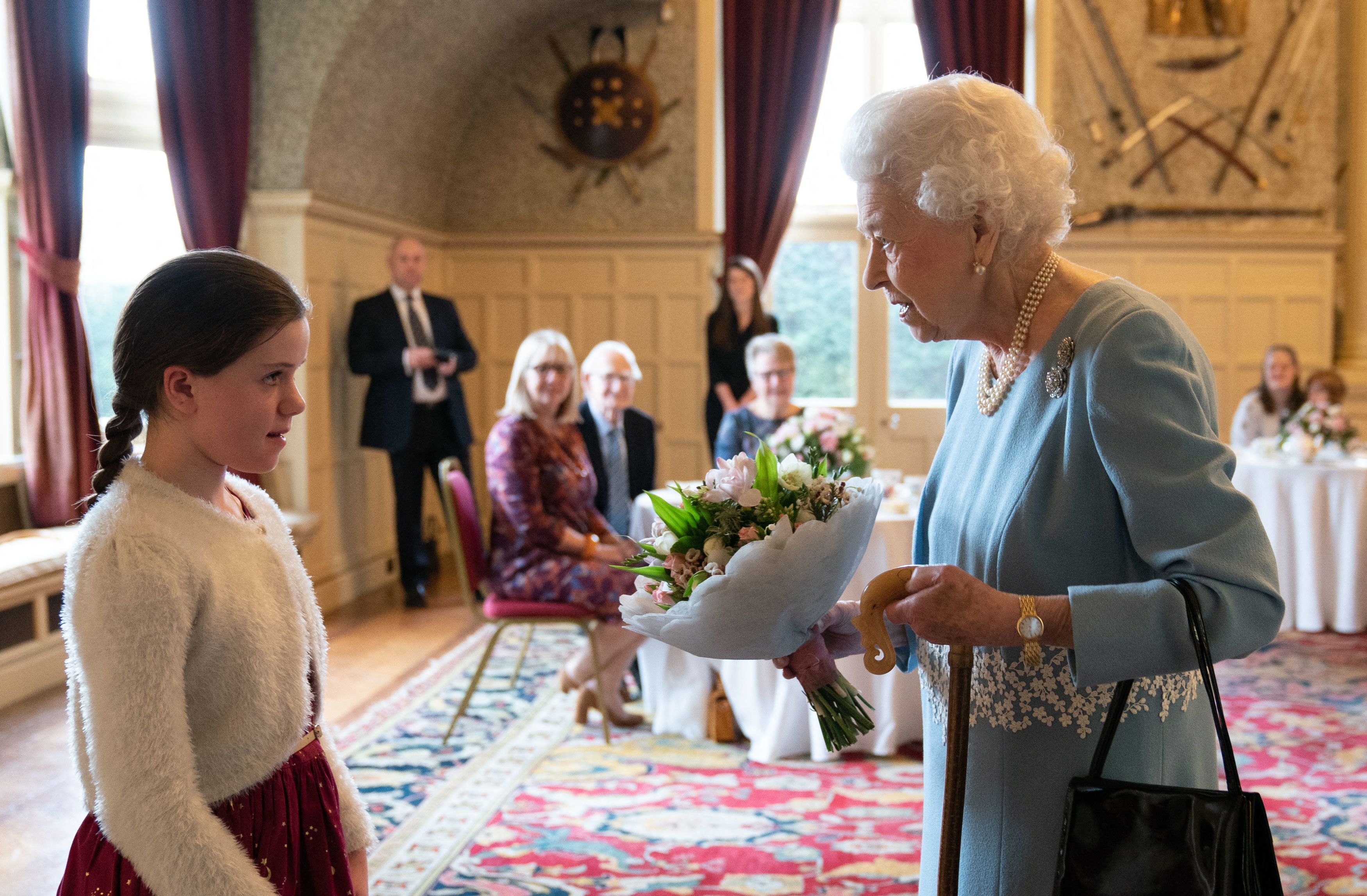The queen receives a bouquet from a girl 