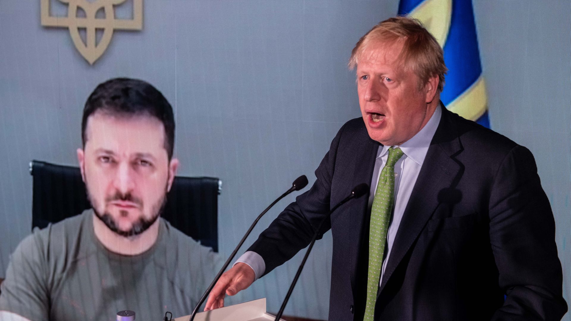 Boris Johnson speaks in front of a live video feed showing Ukrainian President Volodymyr Zelenskyy