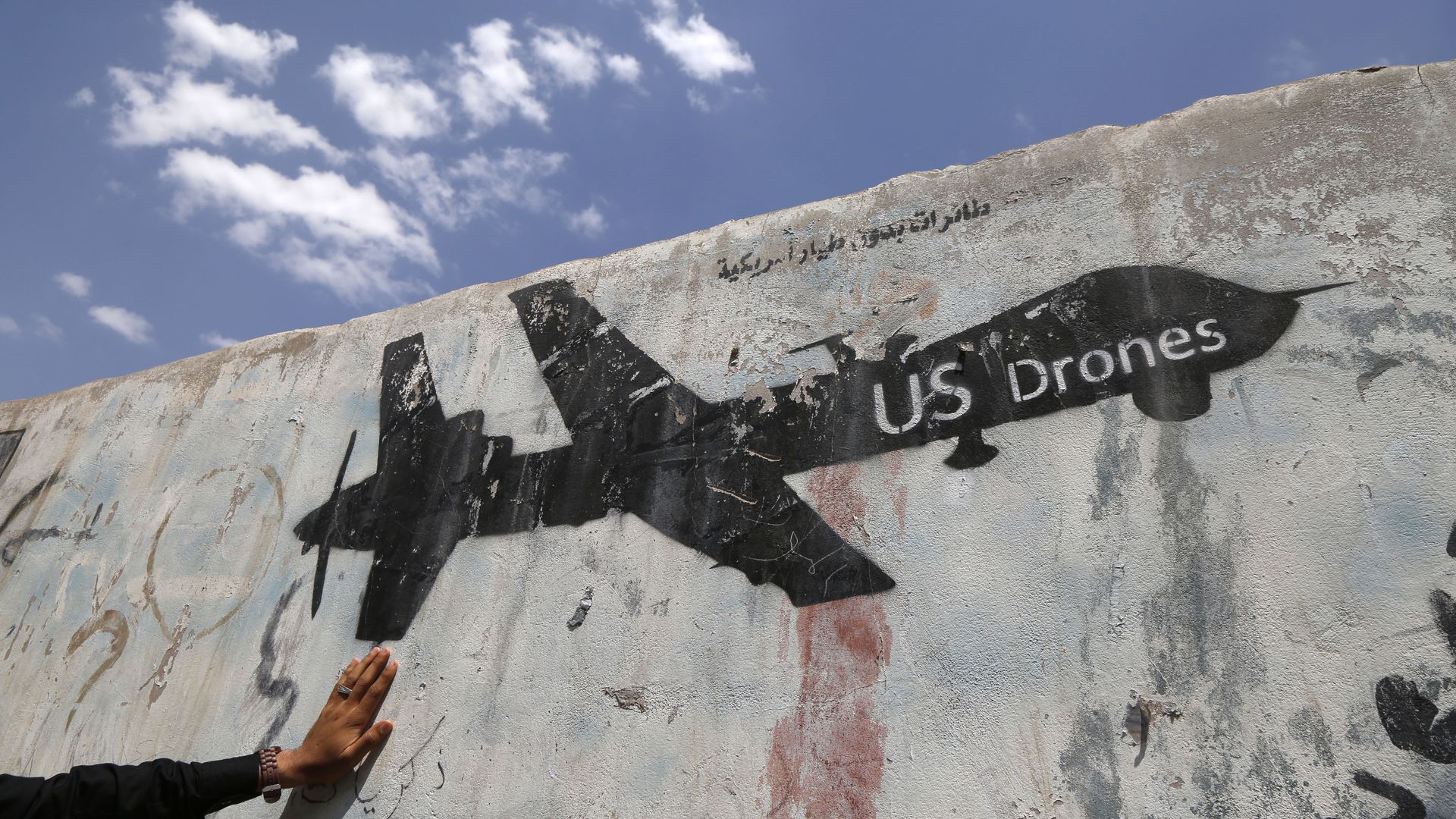 A Yemeni man looks at graffiti protesting against US drone strikes on September 19, 2018 in Sana'a, Yemen.
