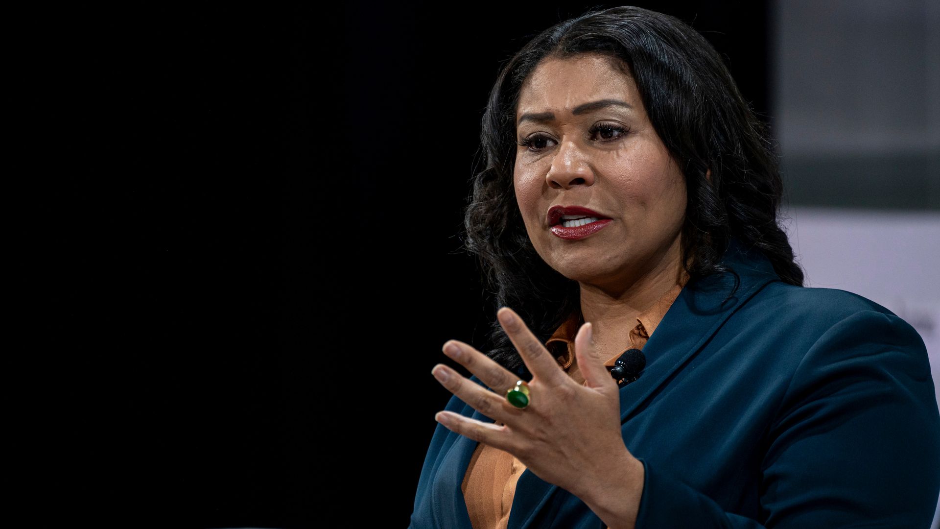 Photo of London Breed speaking on a stage while gesturing with her left hand