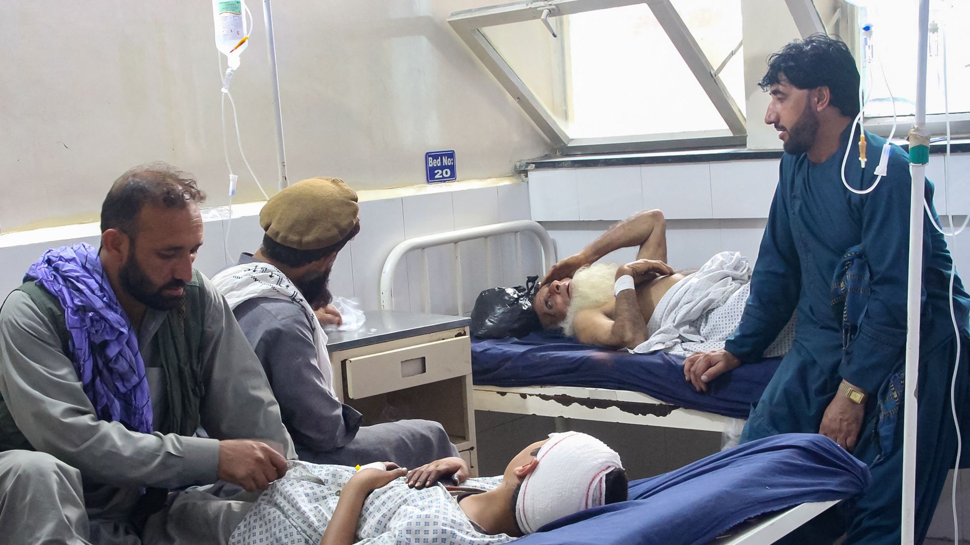 Patients in bed are treated by doctors at an Afghanistan hospital.