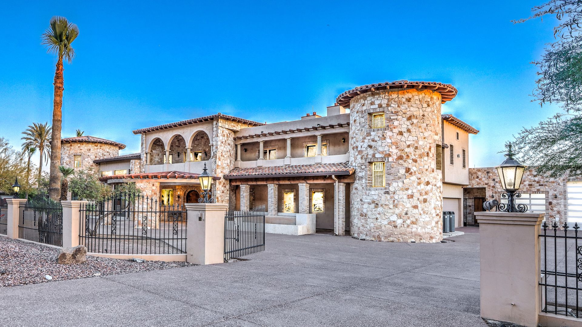 A villa-style mansion with a palm tree out front. 