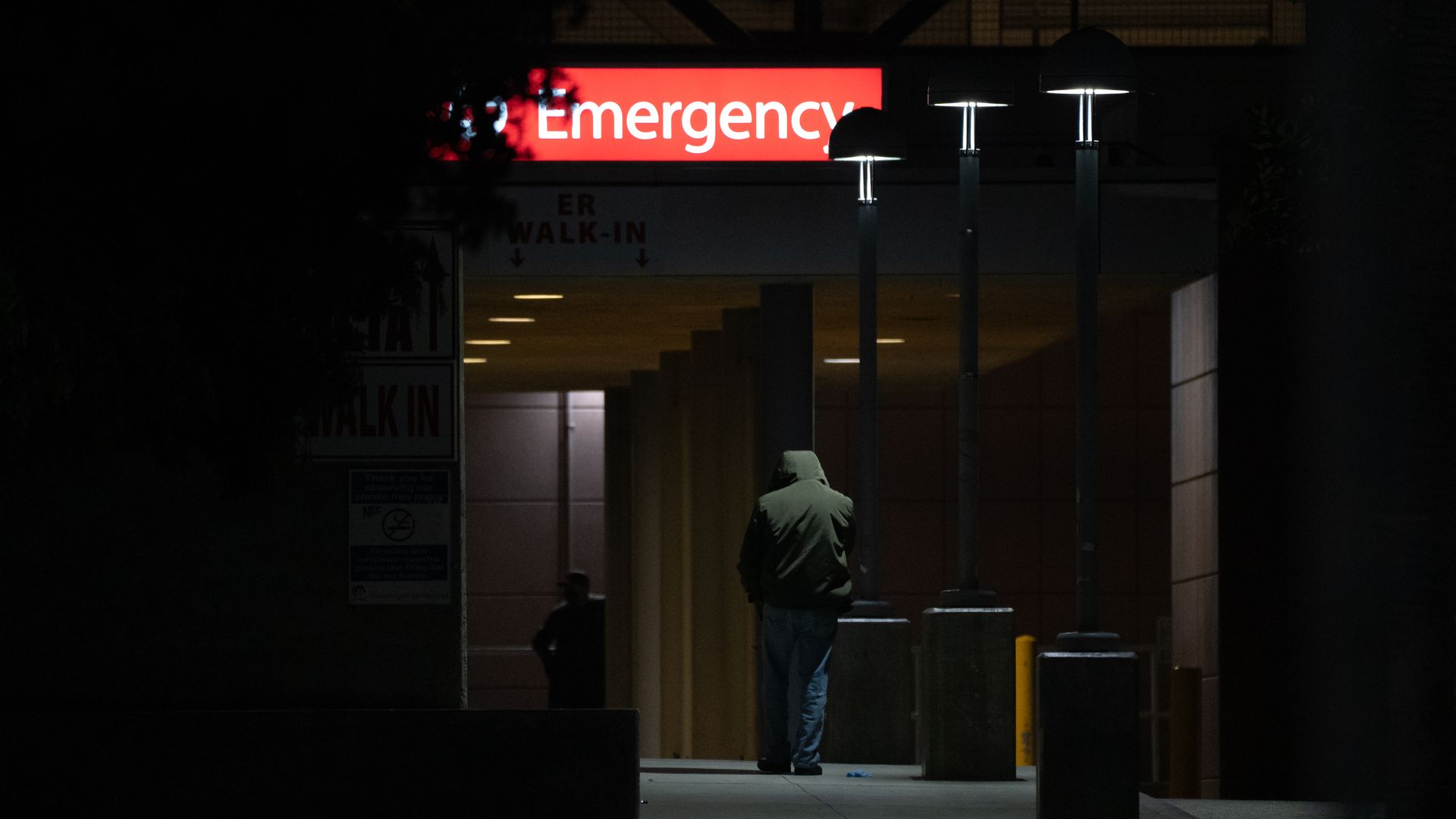Photo of a darkly lit hallway and a red Emergency sign at the top
