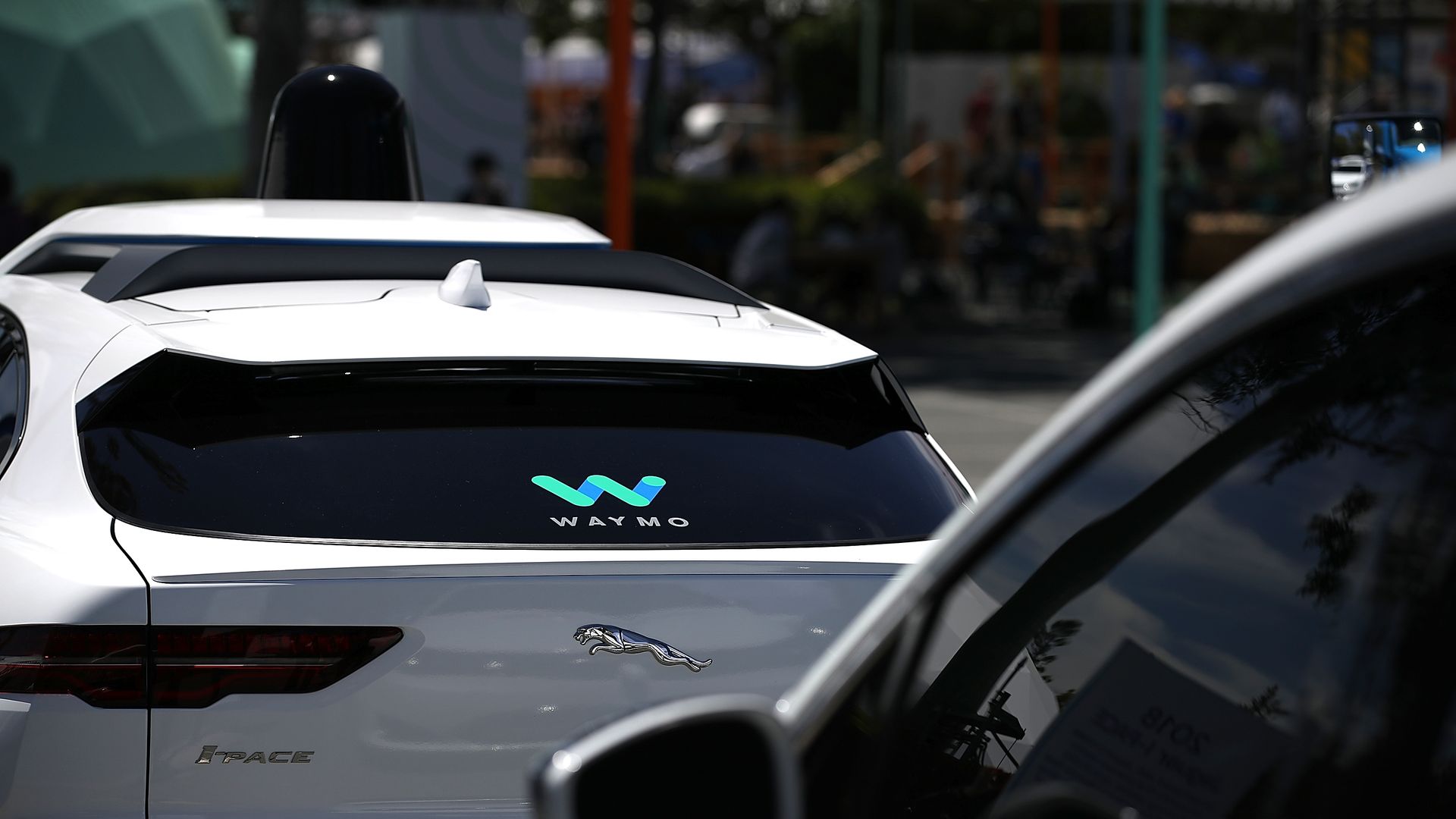 A self-driving car with the Waymo logo on its back windshield