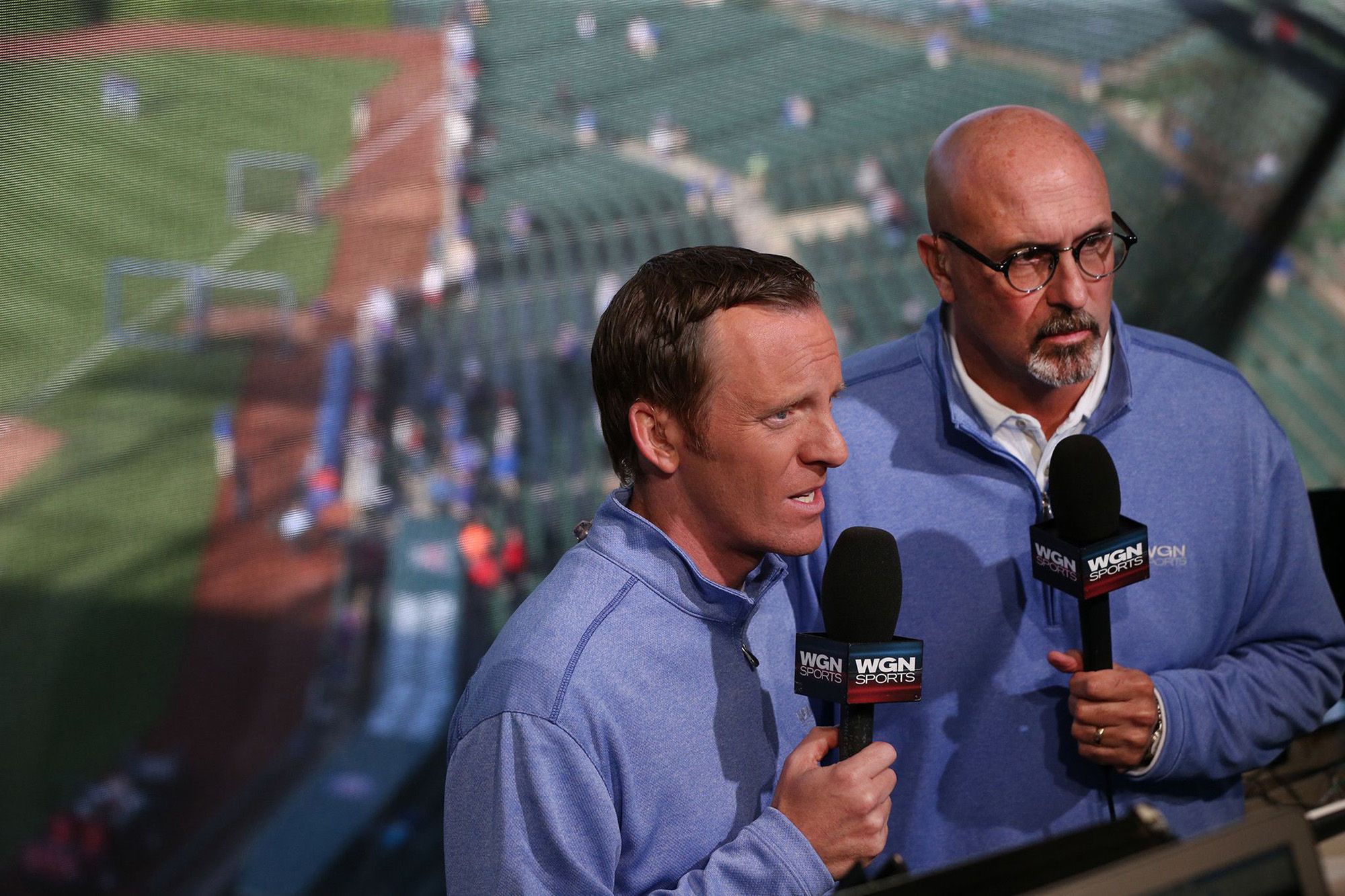 Photo of two broadcasters in a baseball booth 