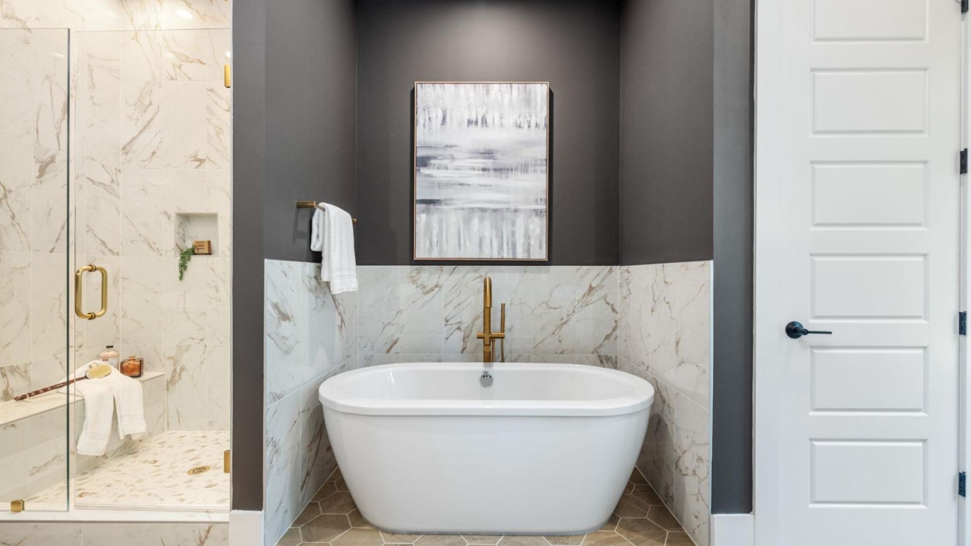 A bathroom with a white tub and standing shower.