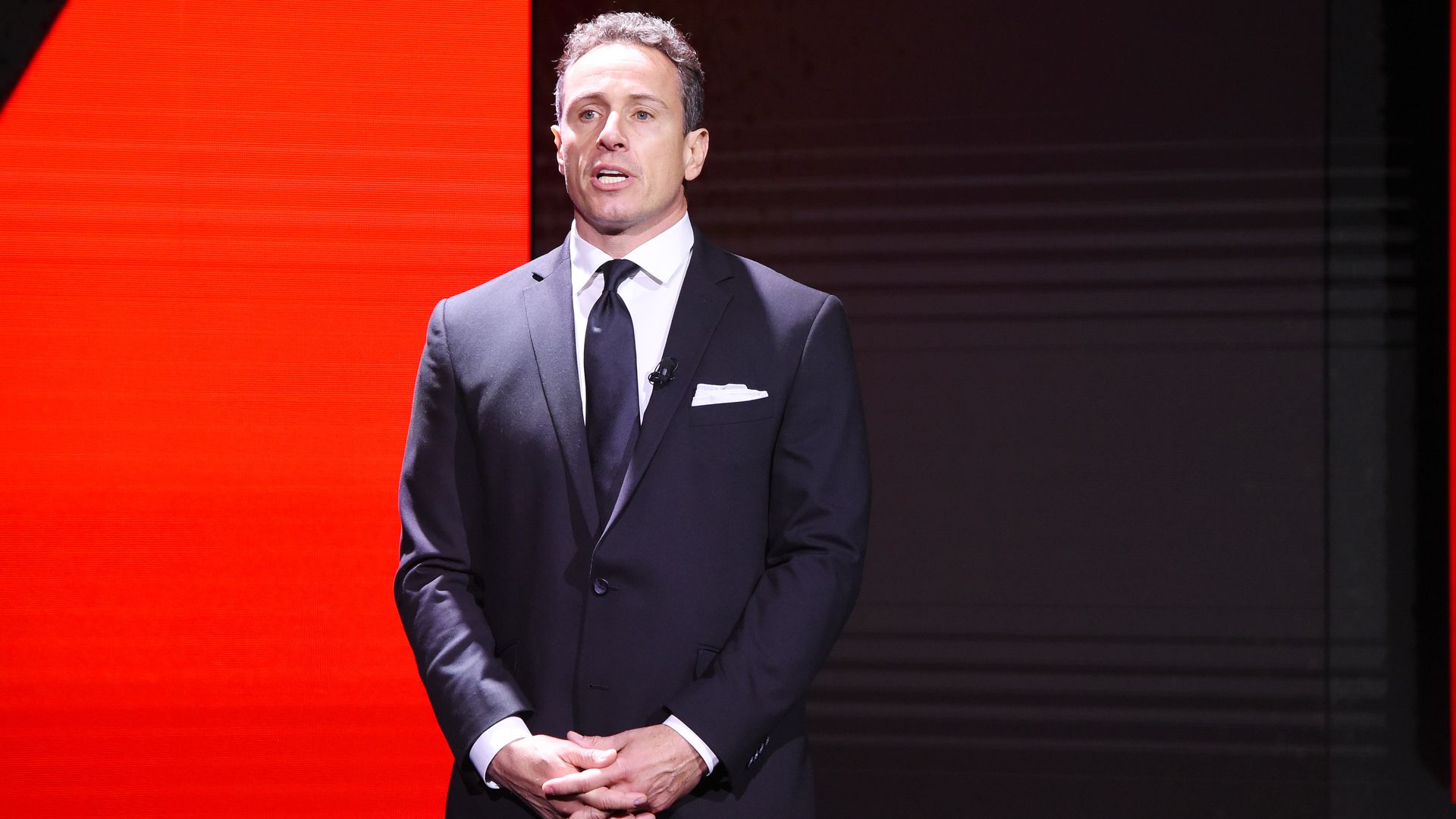 Cuomo stands with his hands folded