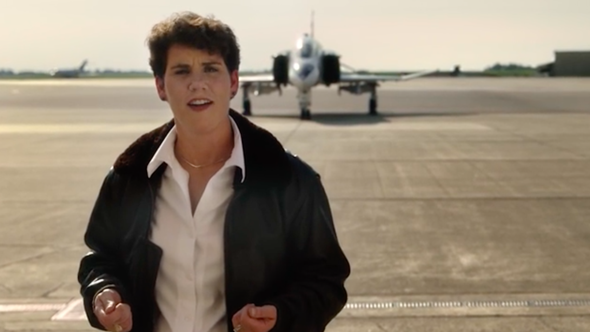 Amy McGrath standing in front of a fighter jet.