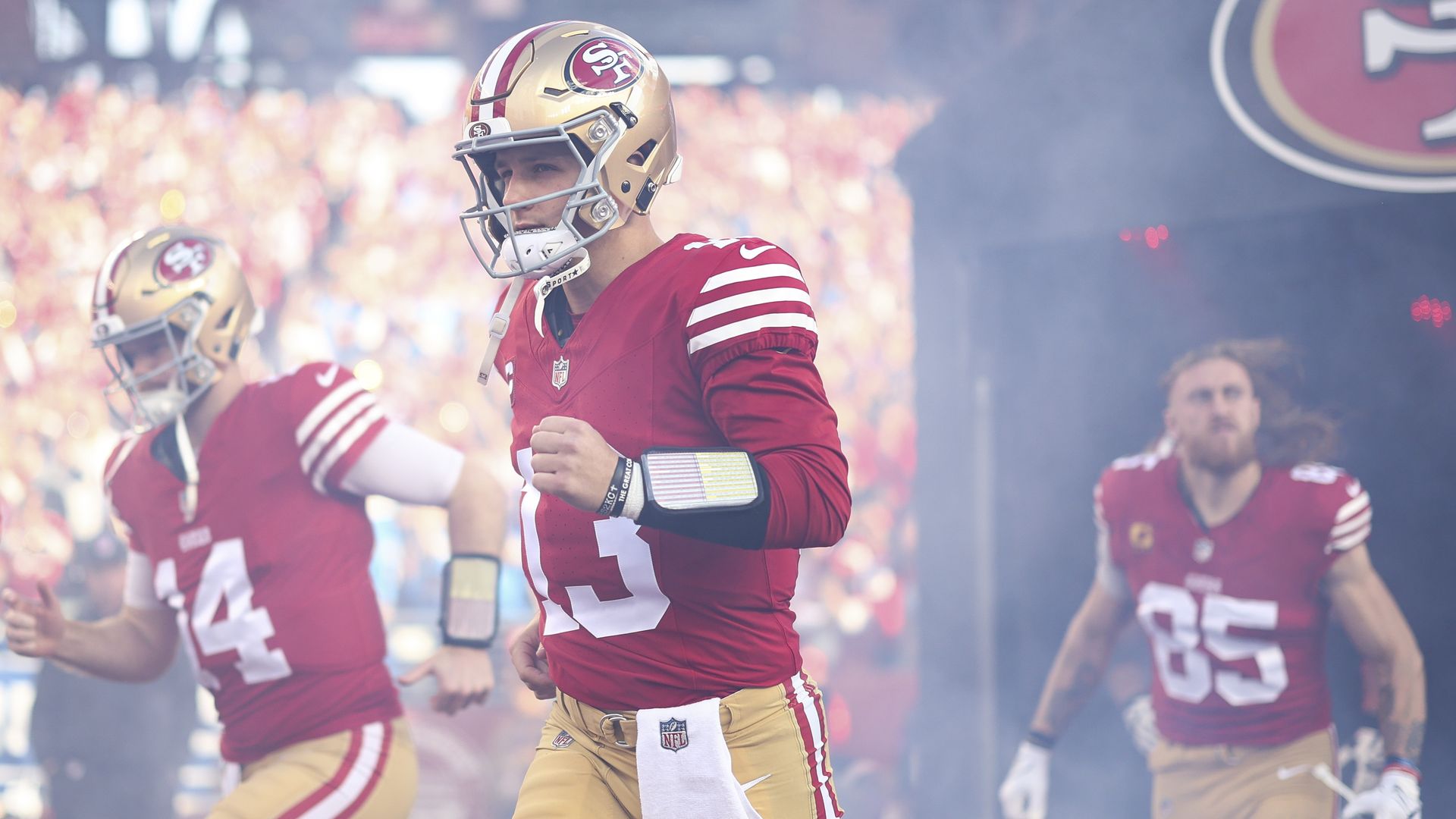 Football players running out of a tunnel.