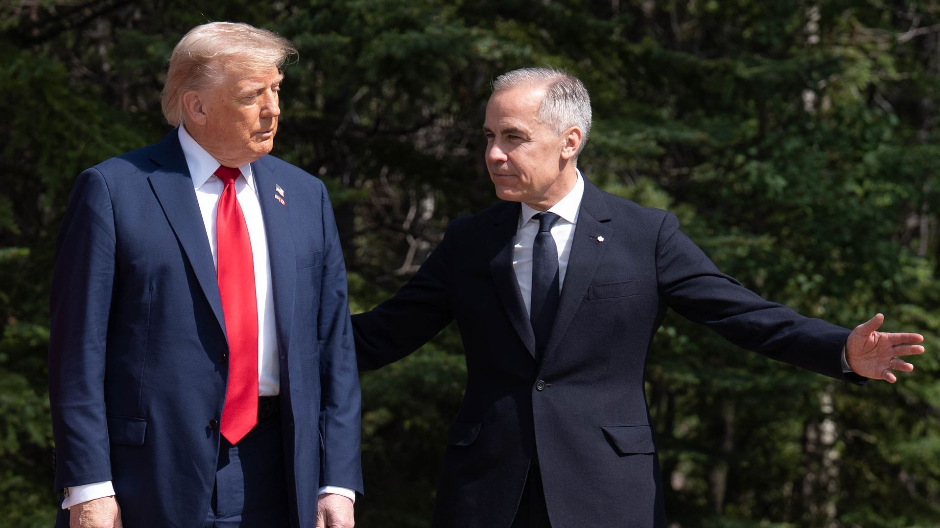 President Donald Trump (R) is greeted by the Prime Minister of Canada Mark Carney, as he arrives at the G7 Leaders Summit on June 15, 2025 in Kananaskis, Canada. 