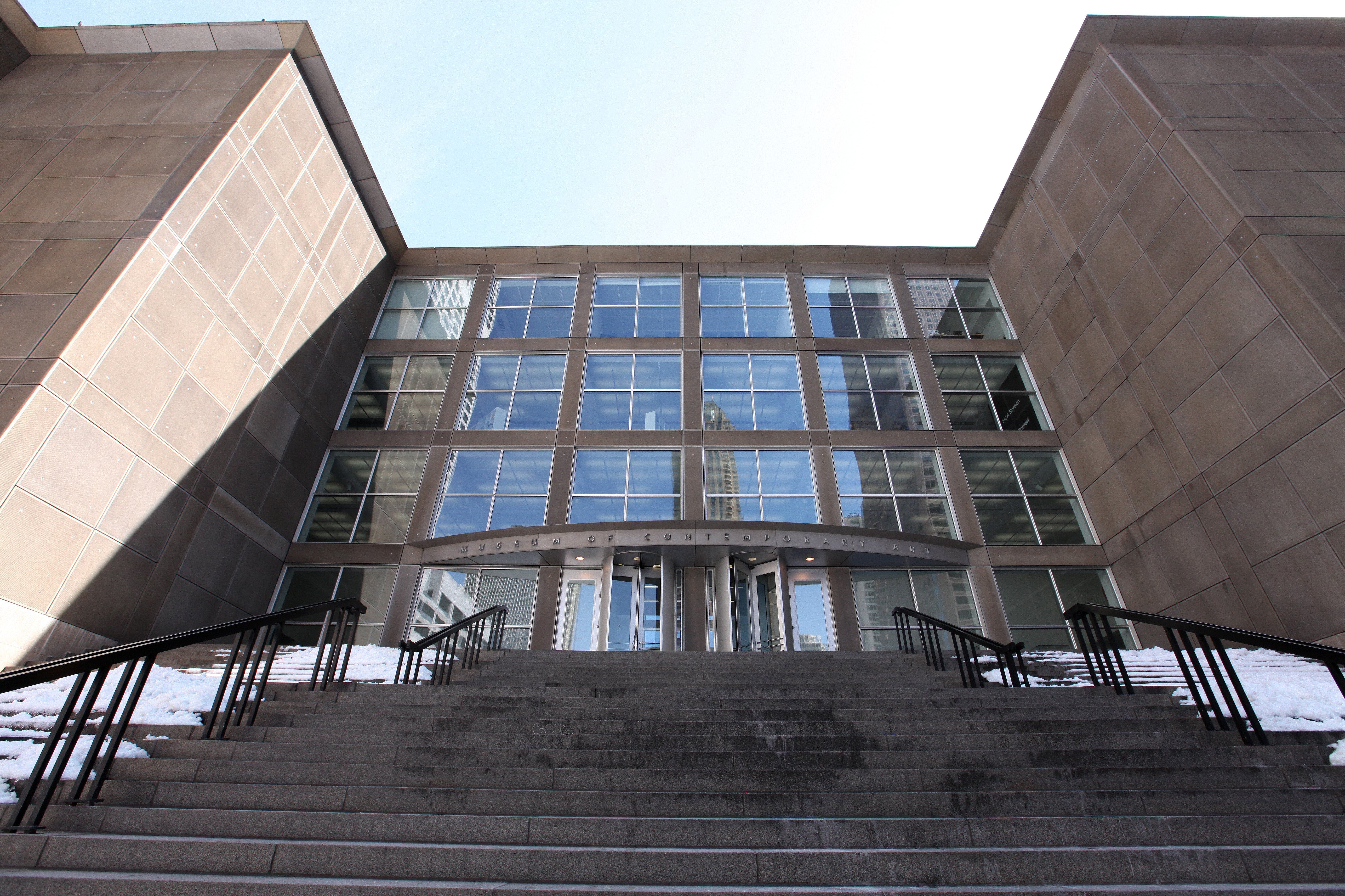 Photo of the front of a building with a big staircase 