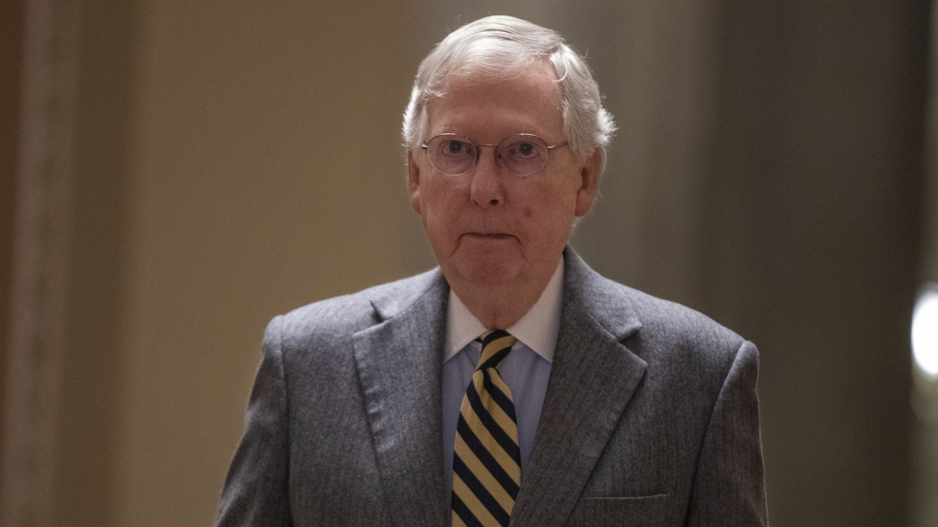 Senate Majority Leader Mitch McConnell walks down a hallway at the Capitol
