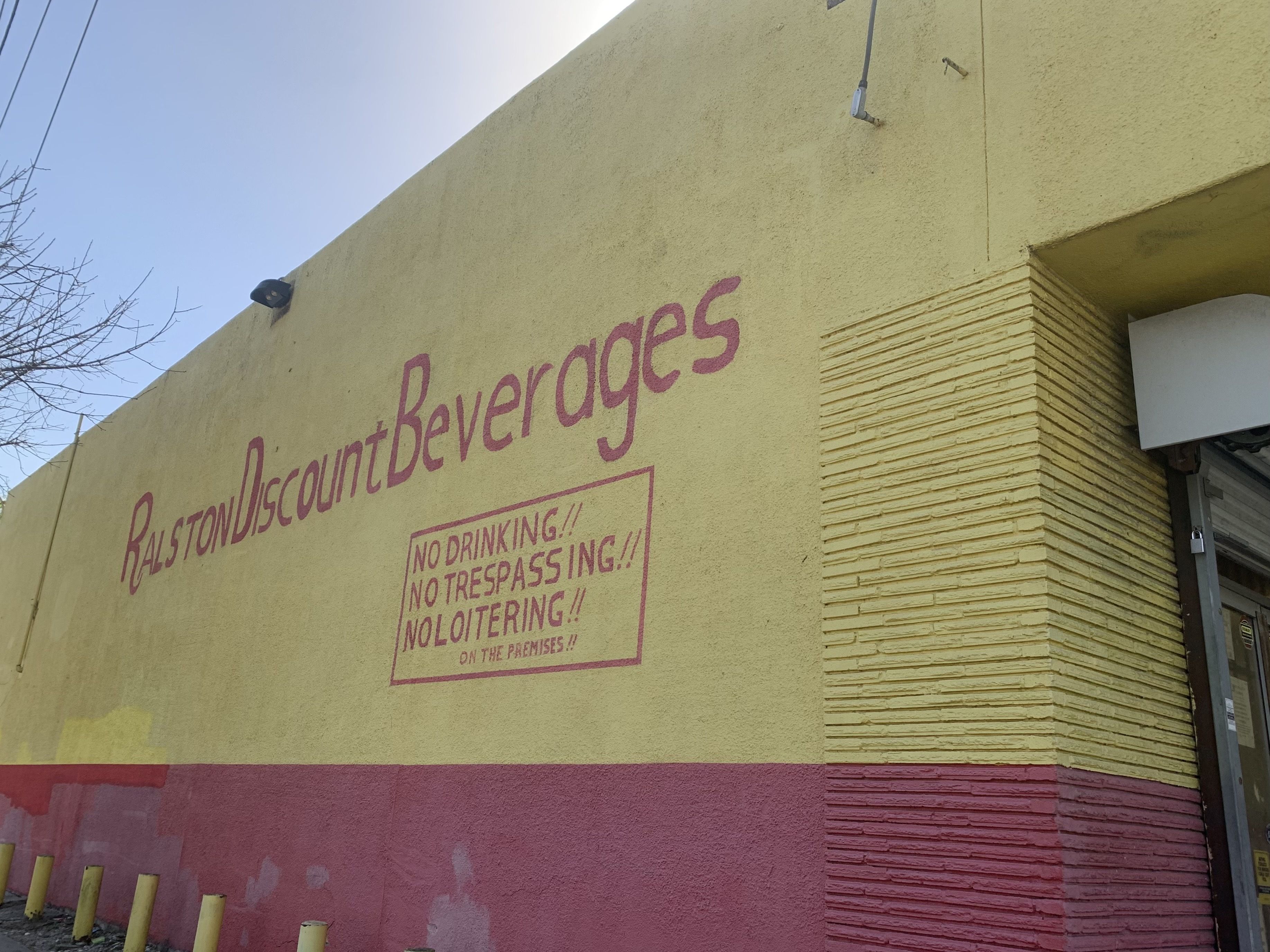Photo of a red and yellow building with the words "Ralston Discount Beverages"