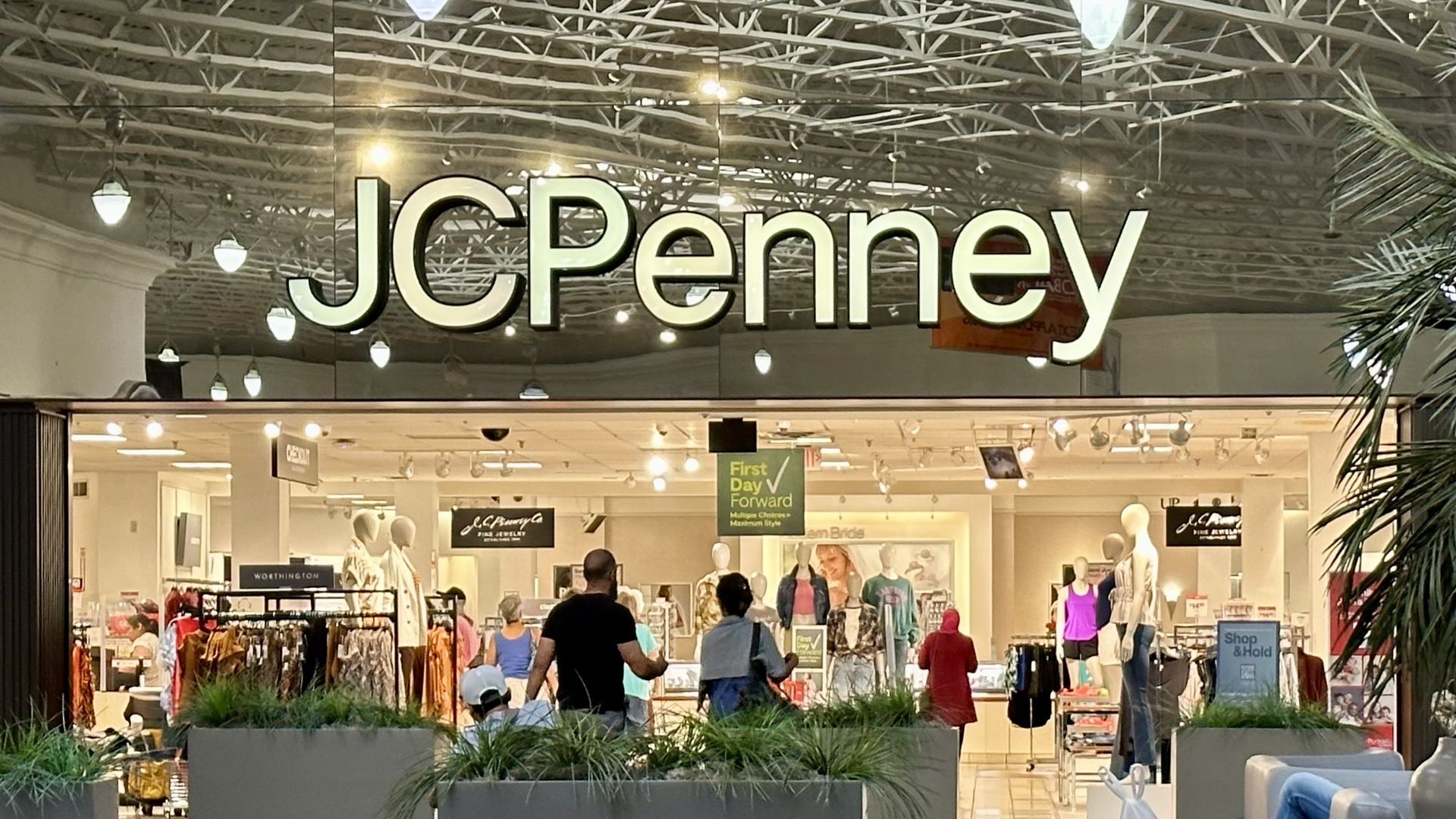 JCPenney storefront in a mall with shoppers walking into the store