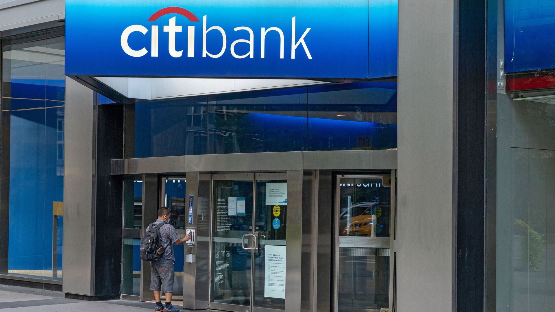 A person entering a Citibank branch in New York City in July.