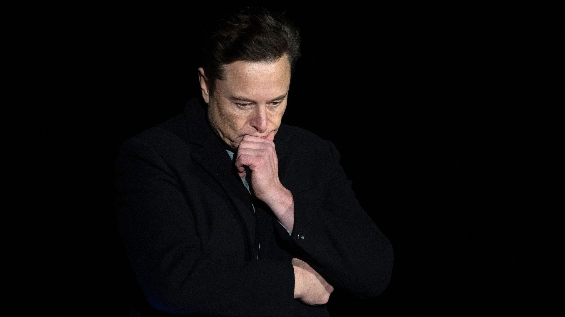 Elon Musk with his face in his hands