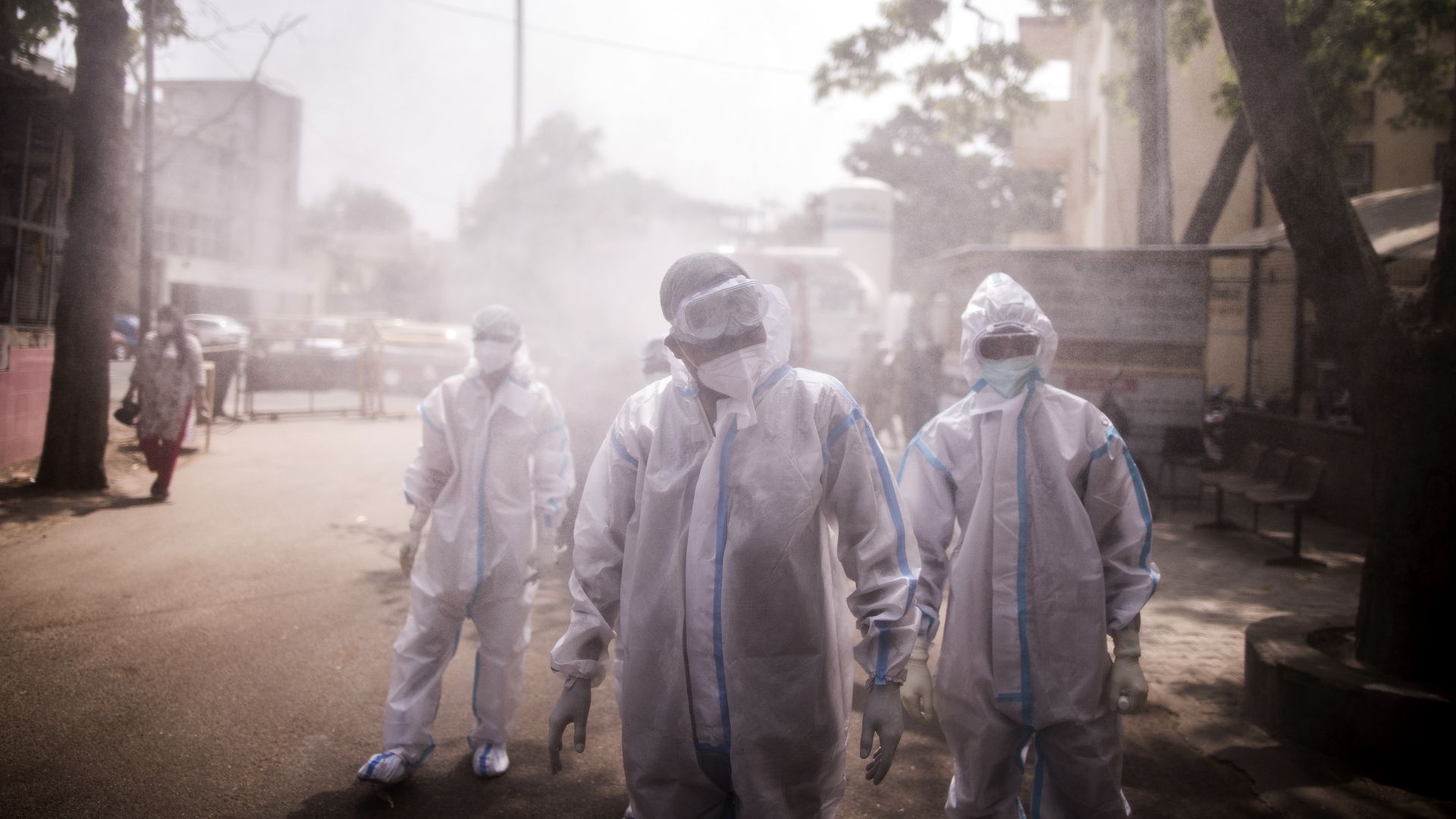 Frontline workers are sprayed with disinfectant at a Covid-19 Care Center set up at the Sarojini Naidu Medical College (SNMC) in Agra, Uttar Pradesh, India, on Monday, May 3