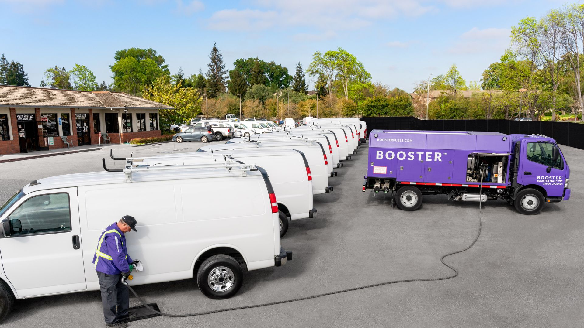 Photo of a Booster fuel delivery truck filling up vans in a parking lot