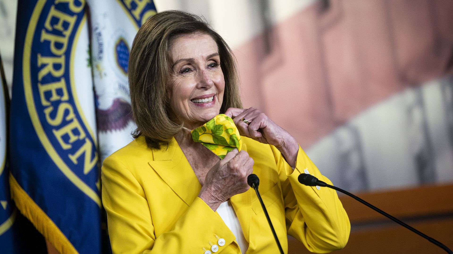 Picture of Nancy Pelosi smiling while taking off her mask