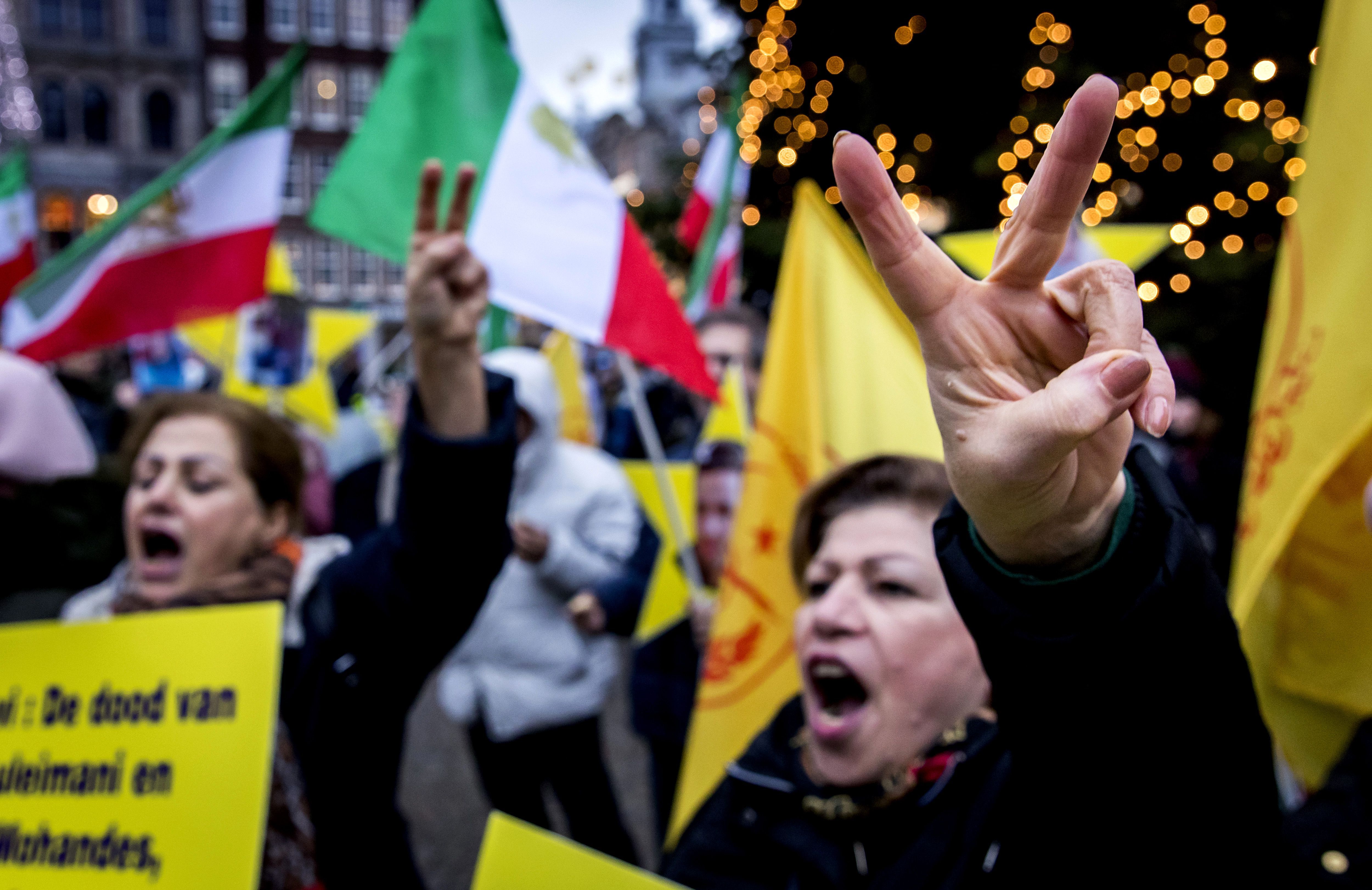 Iranian protestors flash the victory sign during a protest action on Dam Square, Amsterdam, on January 4