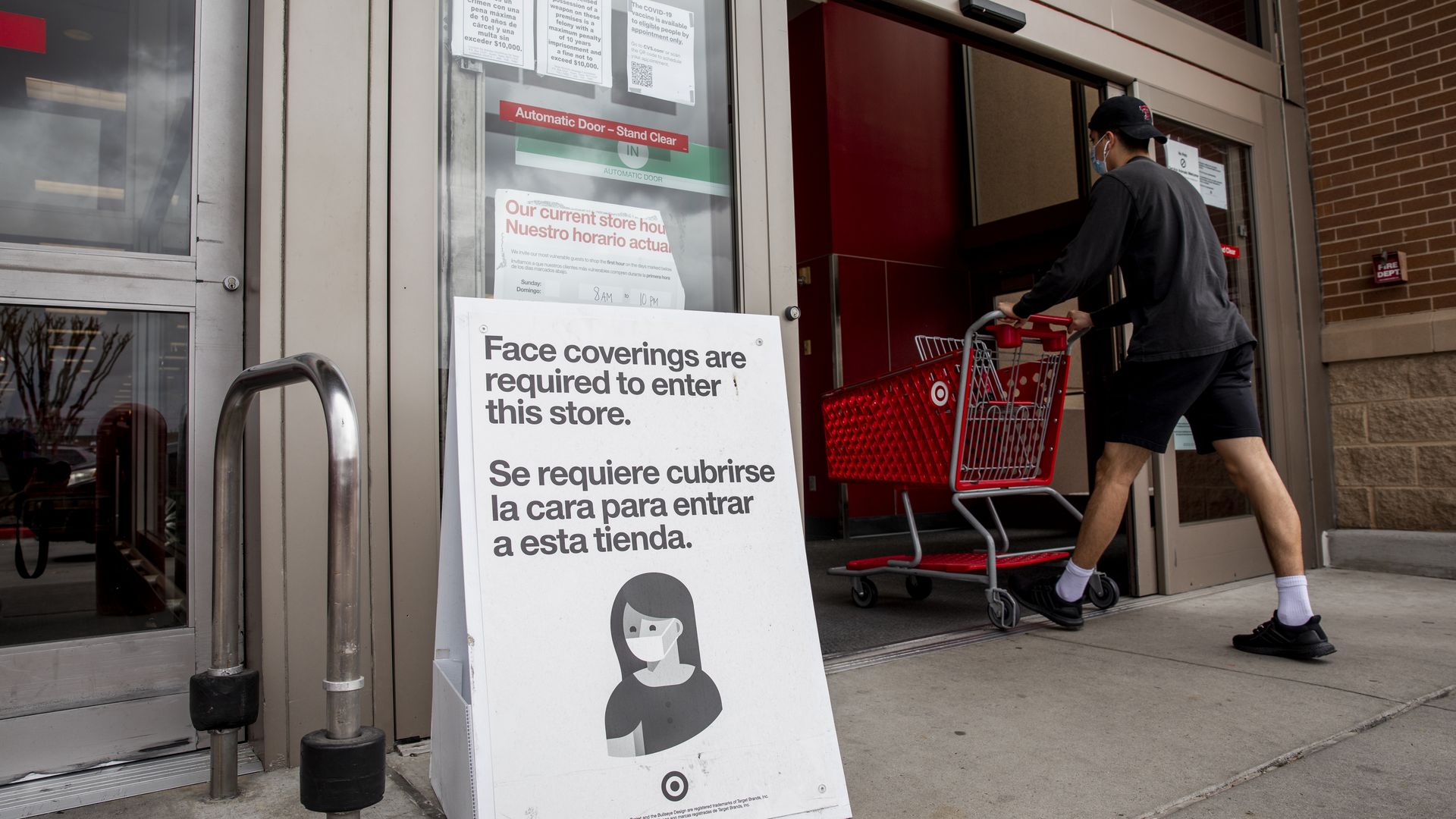 Picture of an entrance to Target with a sign that says customers are required to wear masks indoors