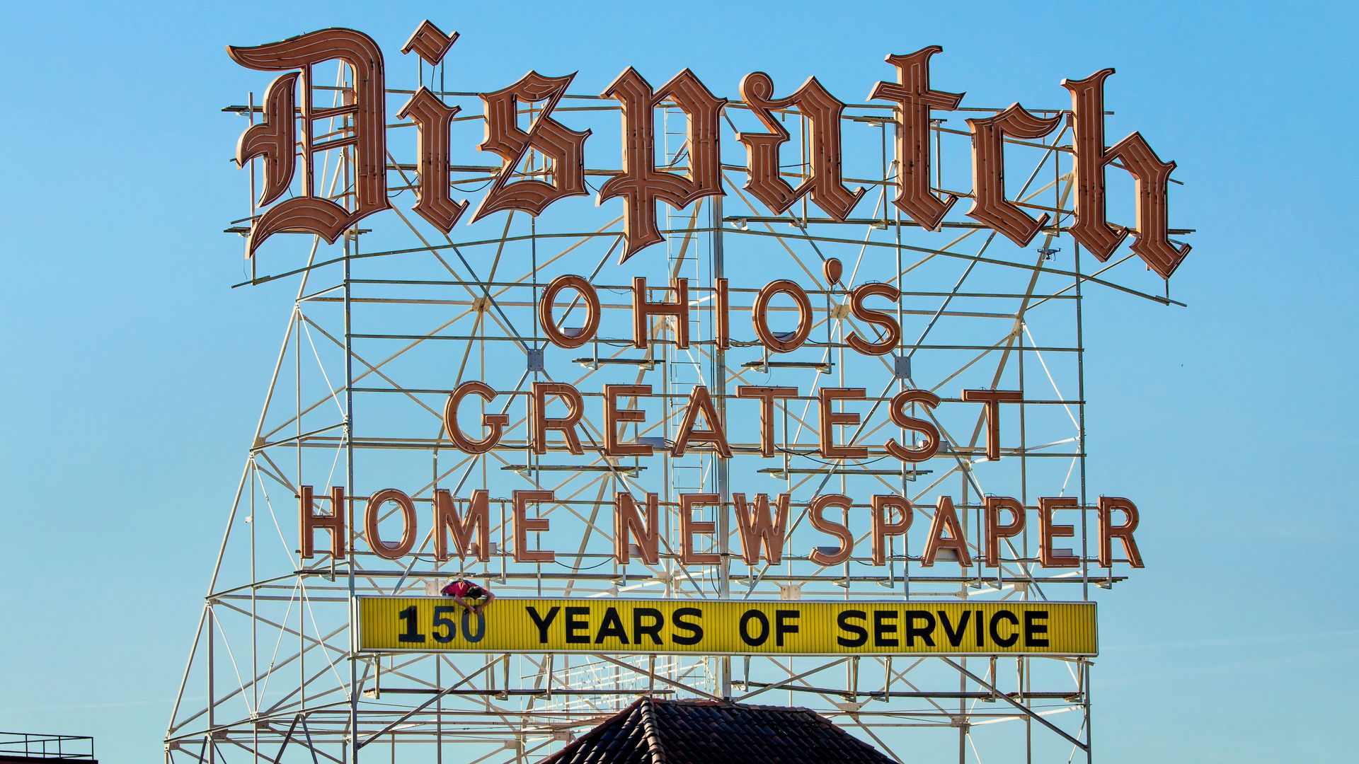 A neon sign reading "Dispatch, Ohio's Greatest Home Newspaper, 150 Years of Service"