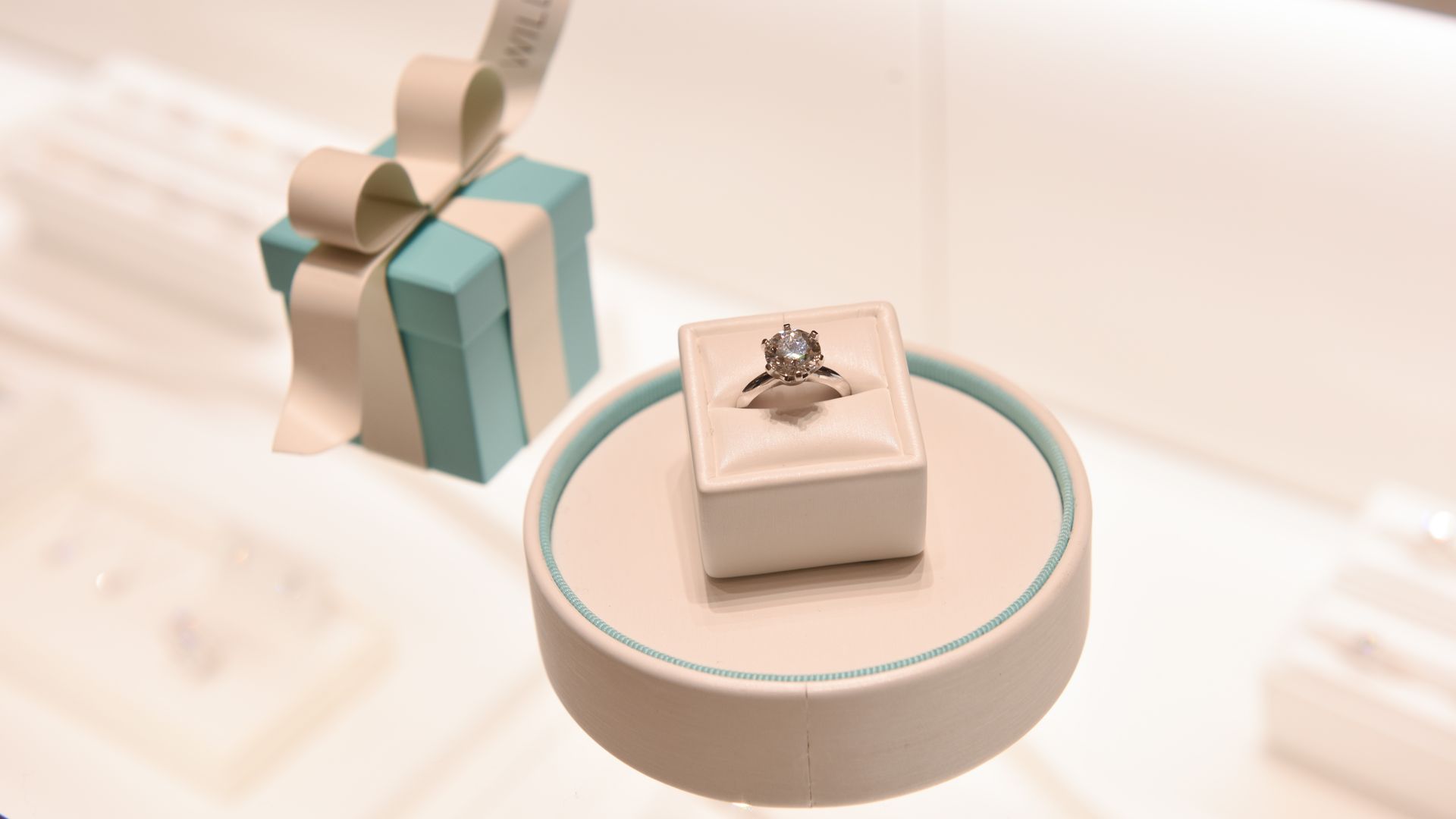 A diamond ring next to a turquoise jewelry box