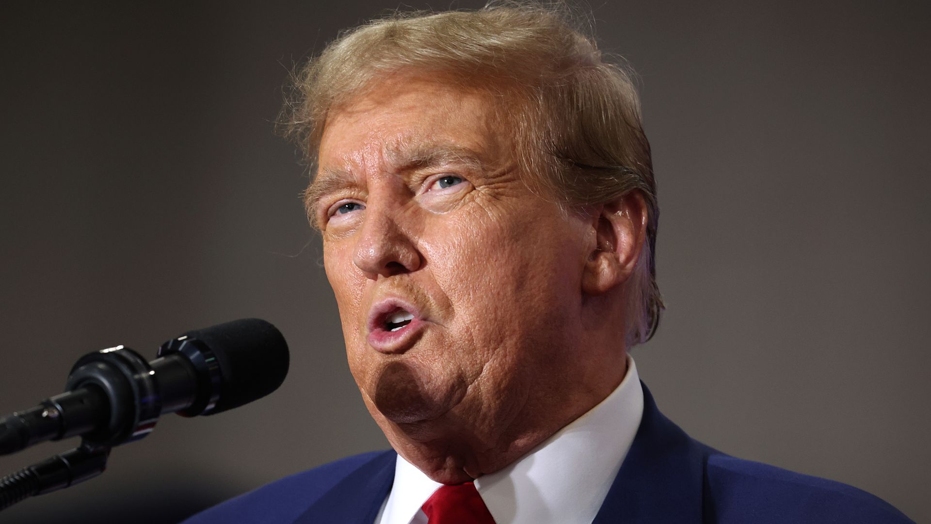 Former President Trump speaks into microphone