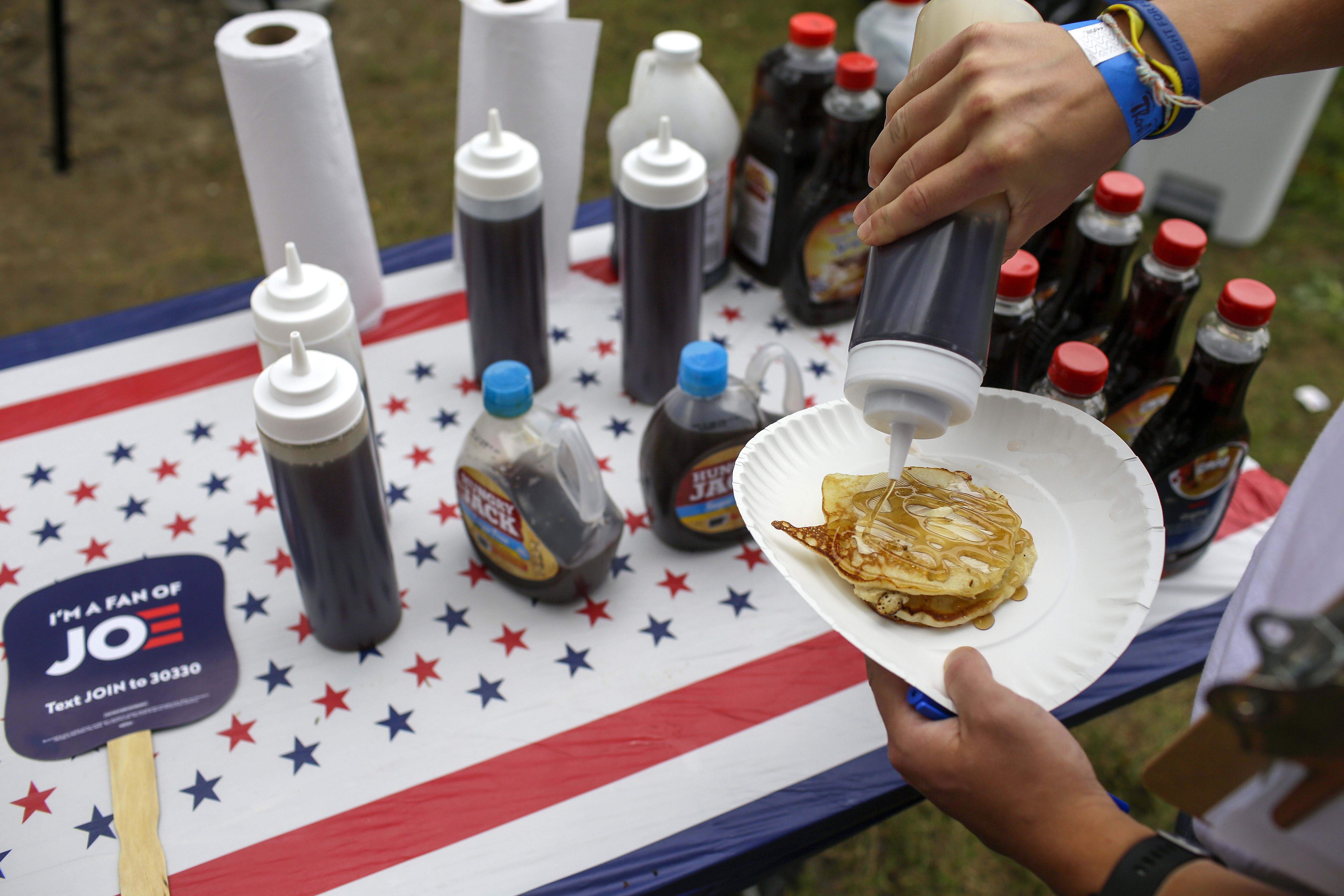 An attendee puts syrup of a stack of pancakes during the Democratic Polk County Steak Fry