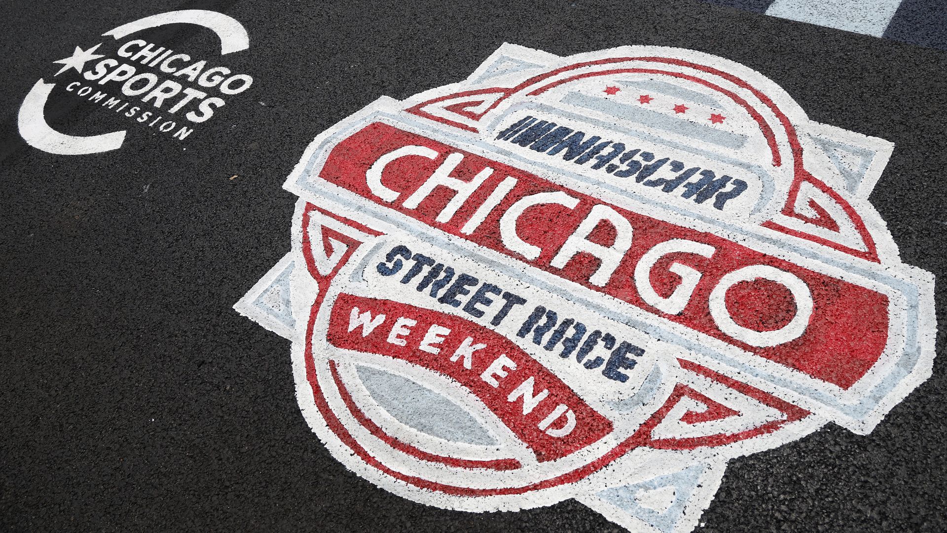A detail view of "NASCAR CHICAGO STREET RACE WEEKEND" and "CHICAGO SPORTS COMMISSION" asphalt stencils during preparations for the Chicago Street Race on June 30, 2023 in Chicago, Illinois. 