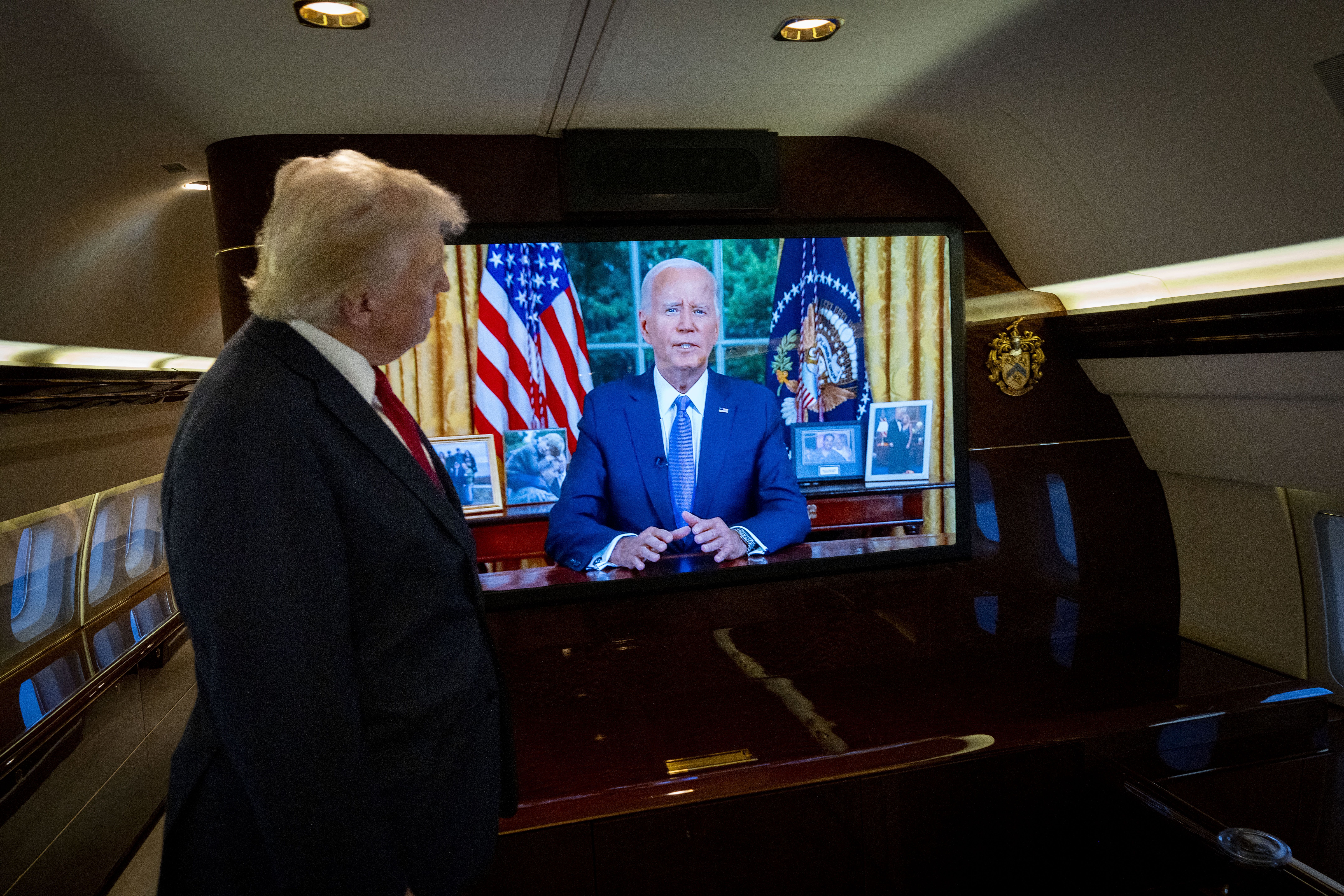 Former President Donald Trump watches aboard his plane, as President Joe Biden addresses the nation from the Oval Office, following a rally in Charlotte, N.C., on Wednesday, July, 24, 2024. 