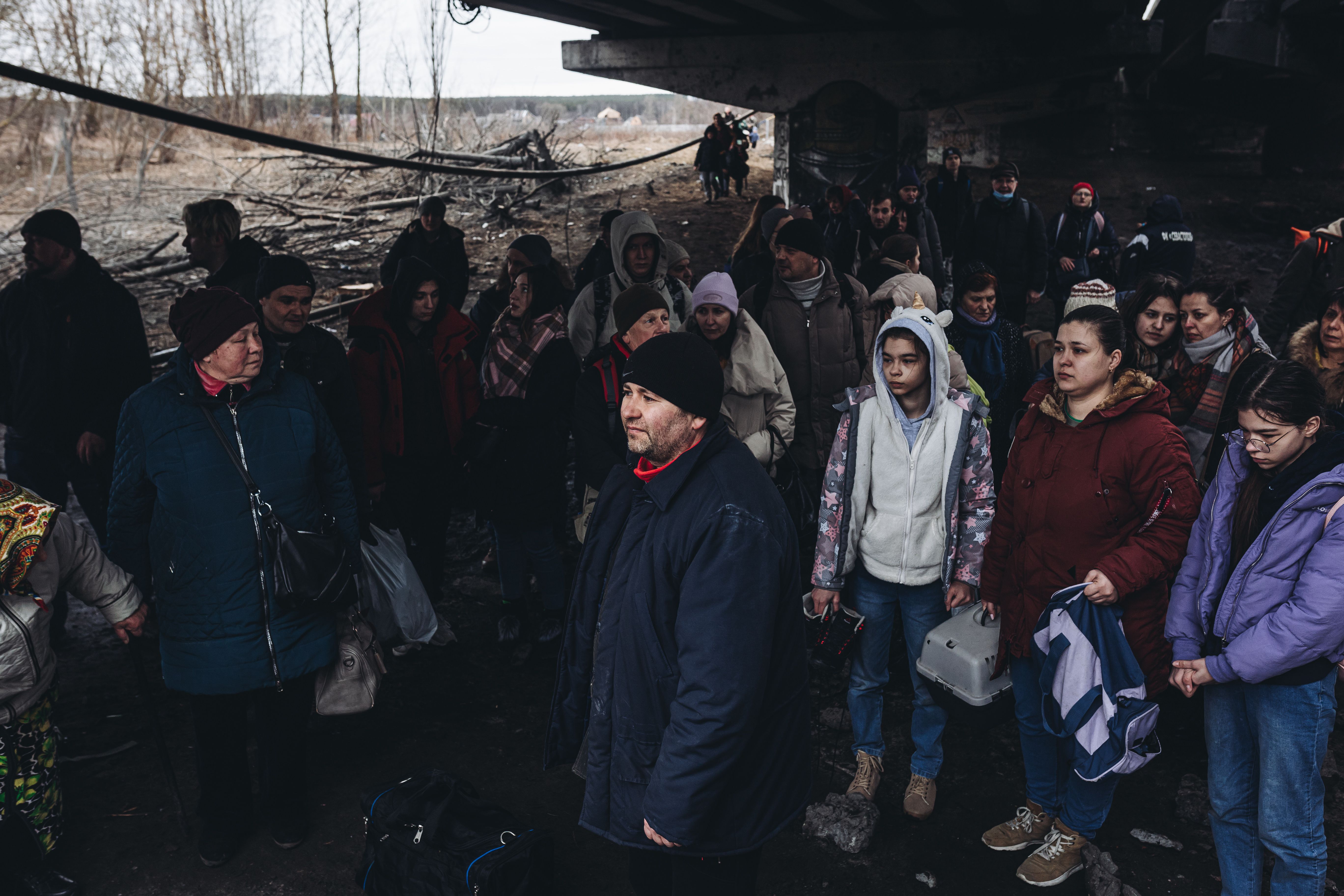 People wait to cross the Irpin river on March 5, 2022, in Irpin, Ukraine. 