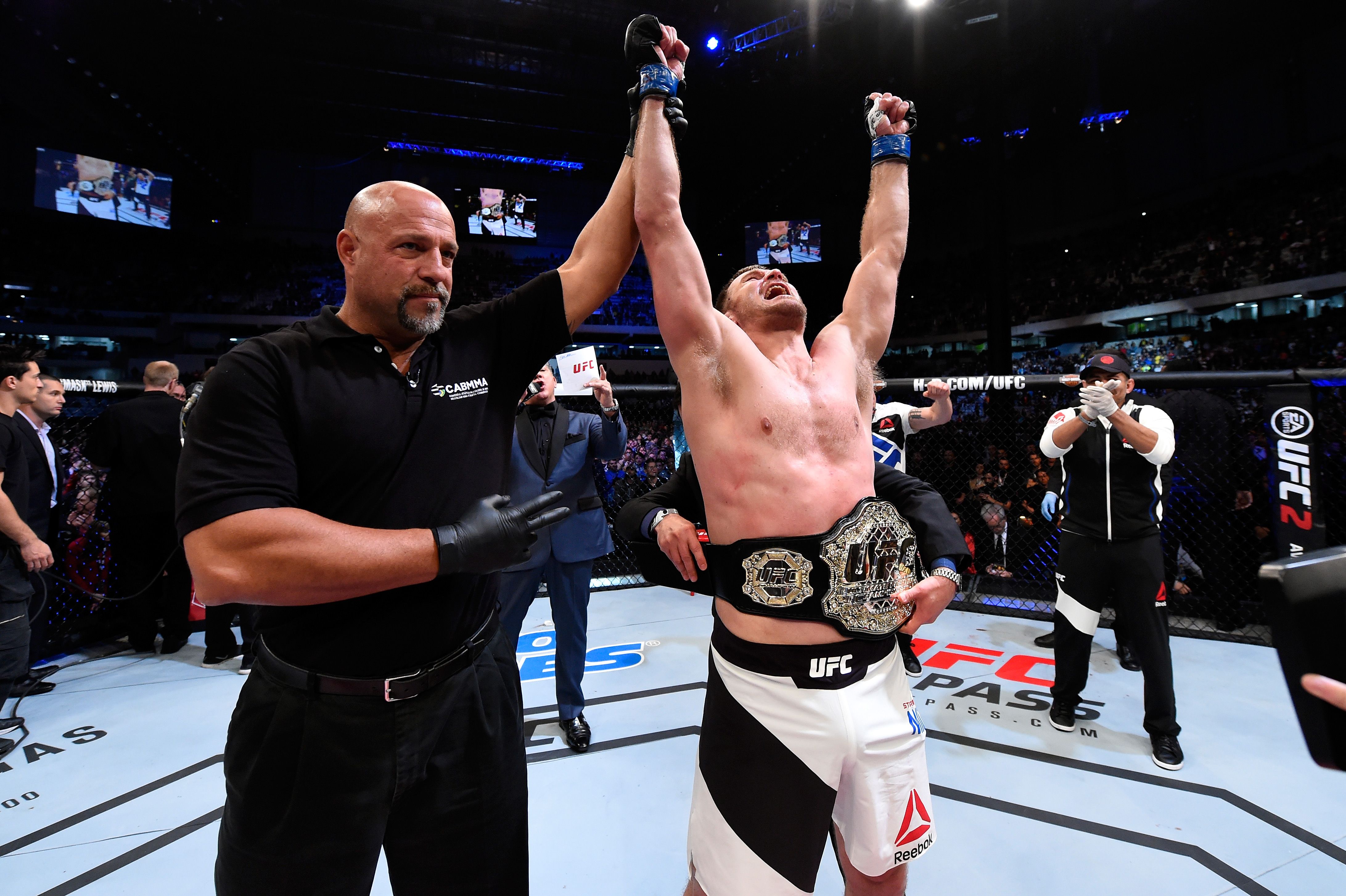 UFC fighter Stipe Miocic's hand is raised in victory.