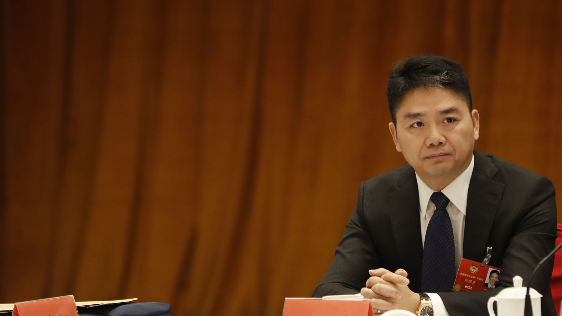 Liu sitting against a red backdrop
