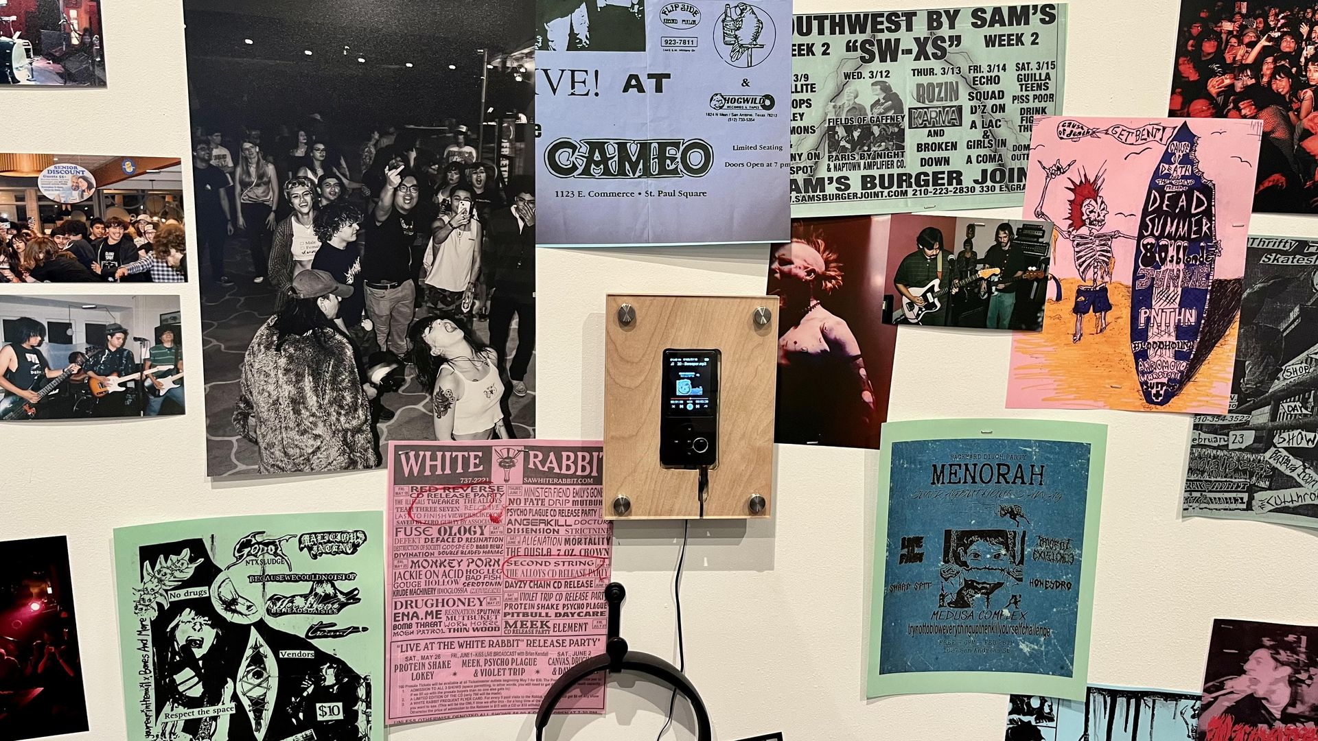 "Mosh Now, Cry Later" features a community archive of local show posters shown here alongside an iPod and headphones on the wall.