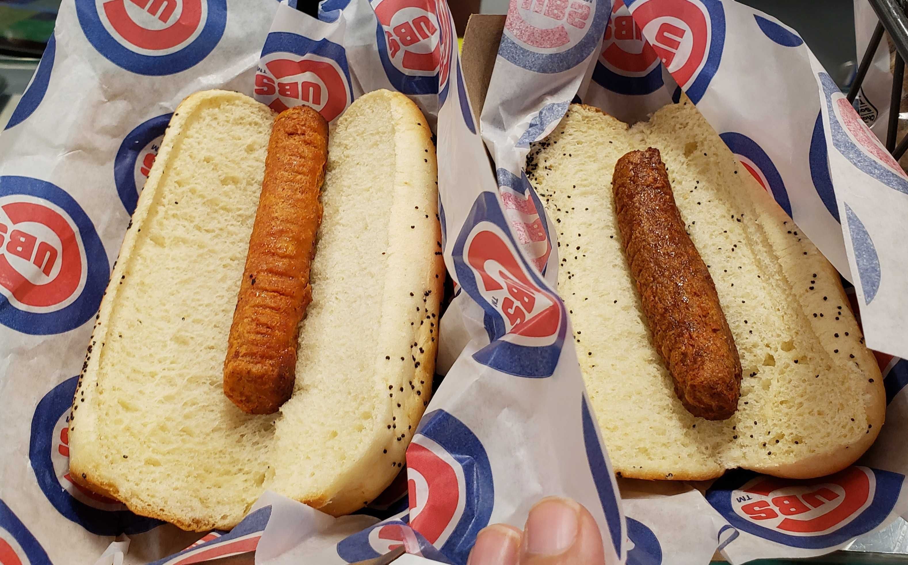 Photo of two hot dogs on wax paper. 