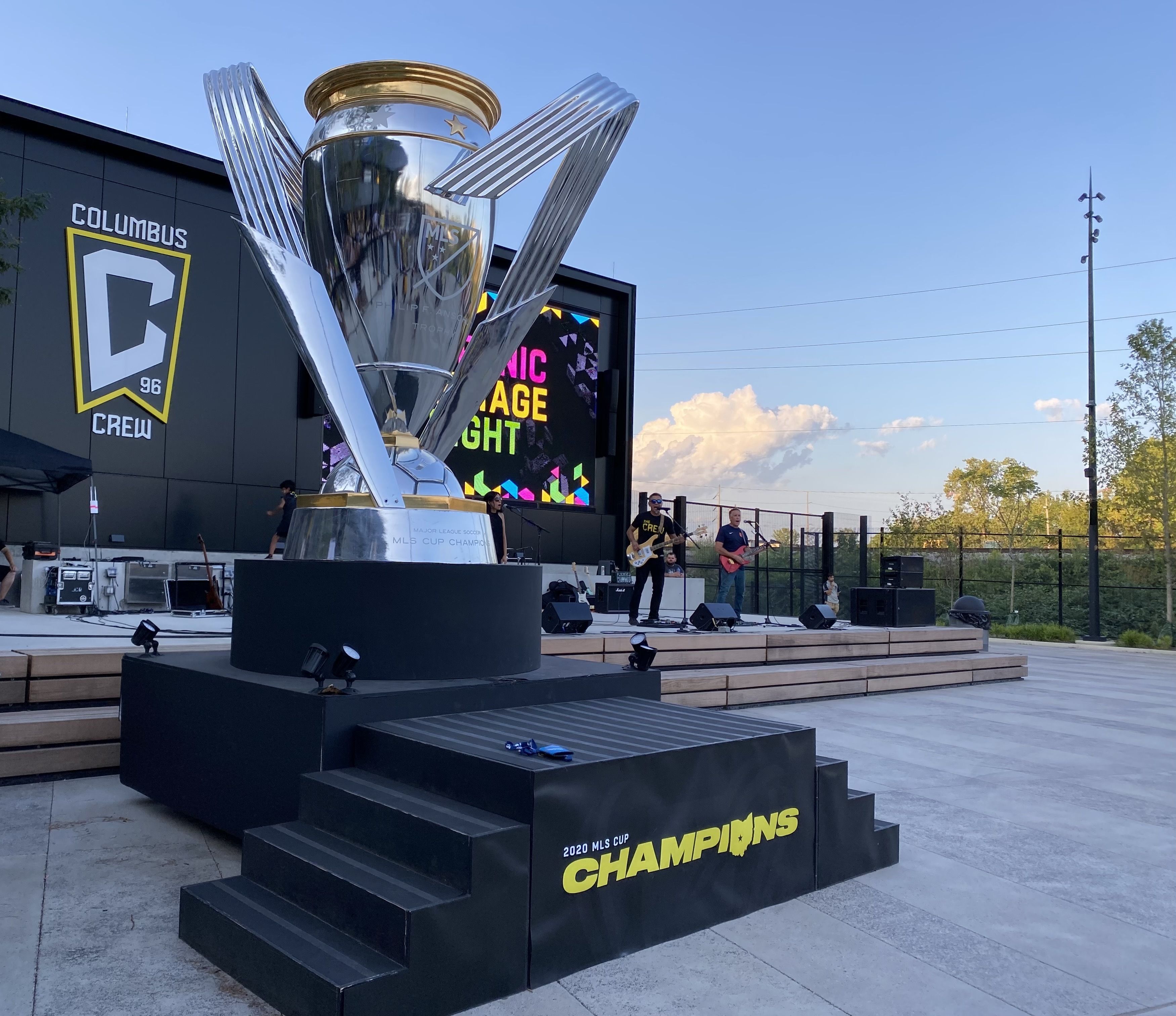 A large-sized trophy on display outside the Columbus Crew MLS stadium, with the word "Champions" written in front.