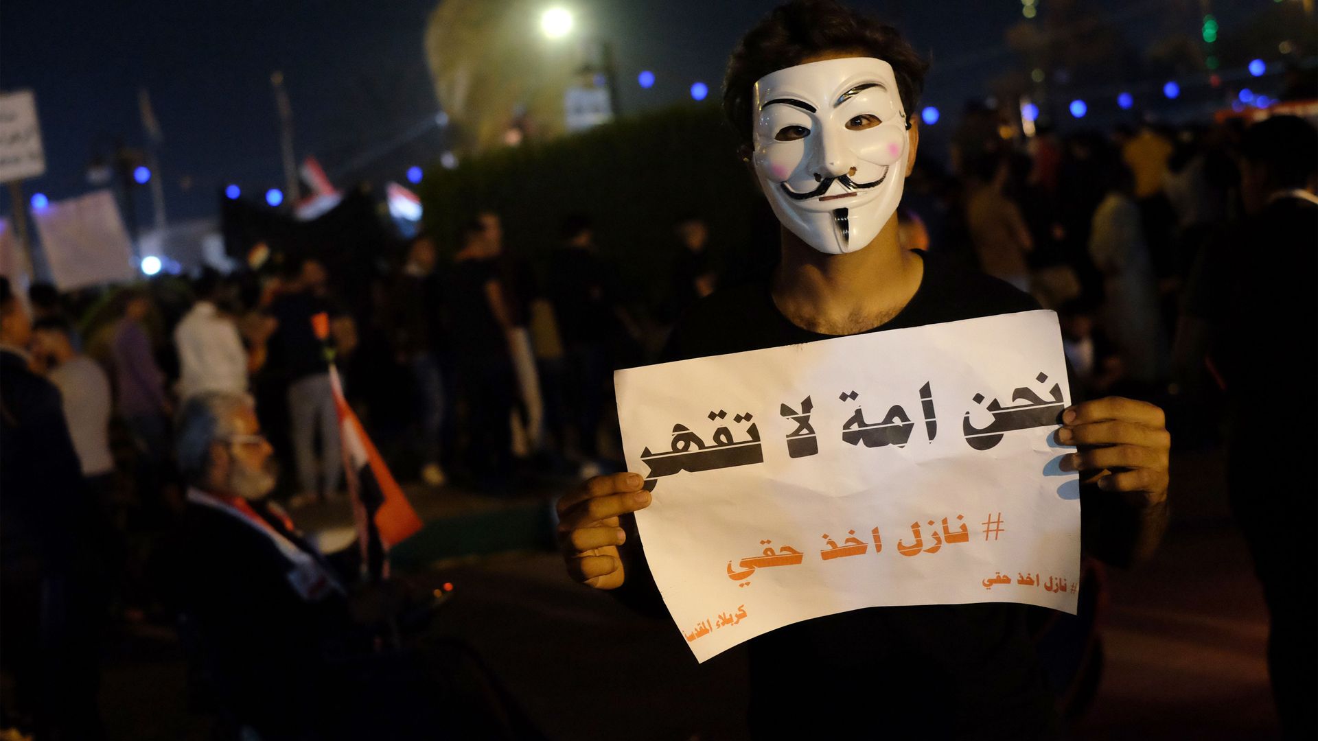  An Iraqi protester holds a placard during ongoing anti-government demonstrations in the Shiite shrine city of Karbala, south of Iraq's capital Baghdad, on November 1