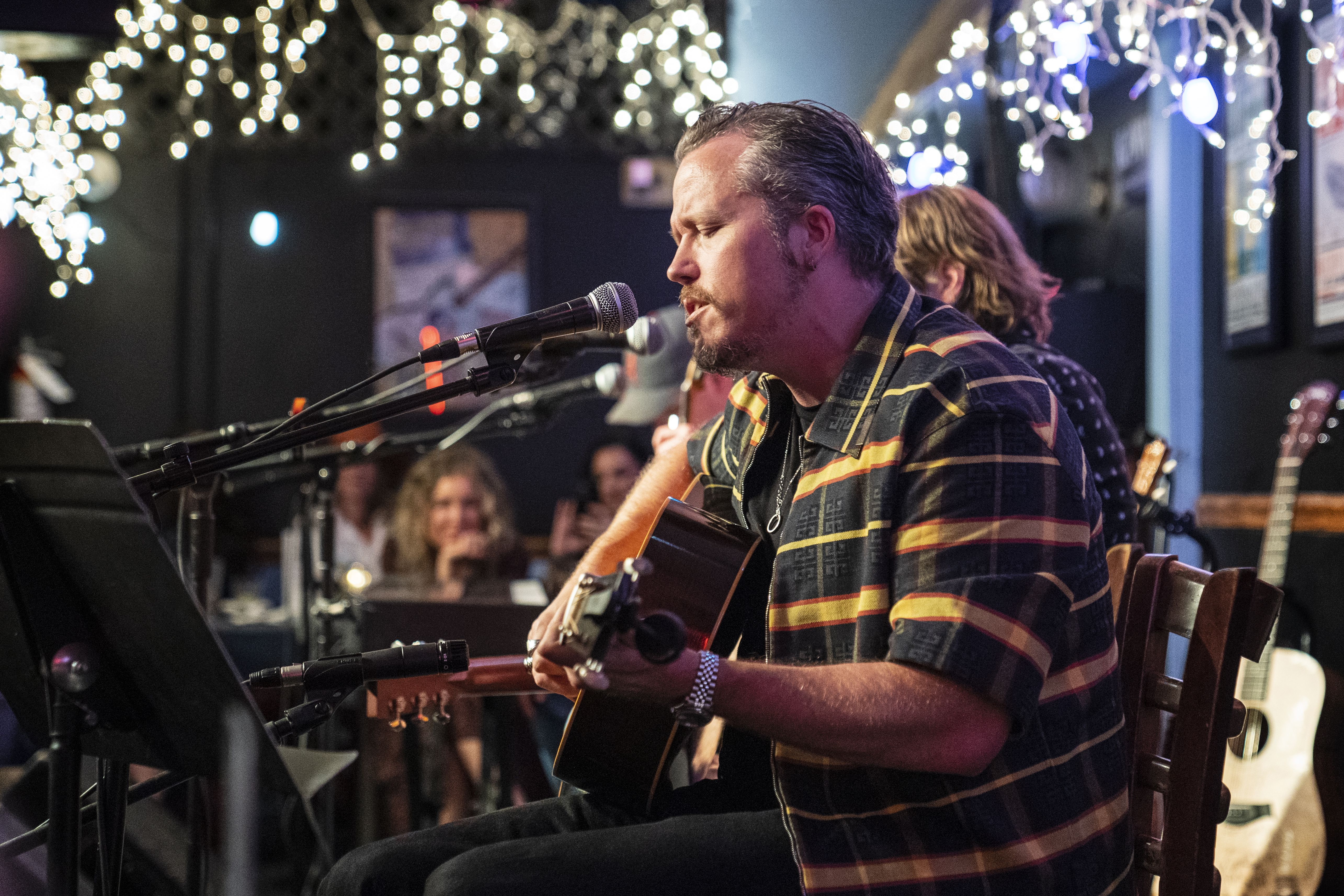 Jason isbell in a yellow striped shirt at the Bluebird Cafe