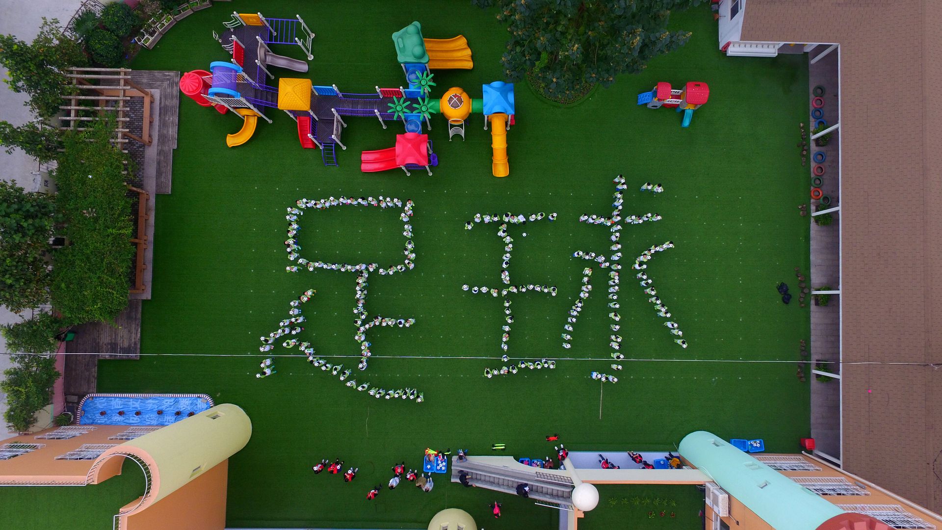 Kindergarten children make a pattern of Chinese characters "football" during choreographed football exercises at Yangzhou University Kindergarten on October 11, 2016 in Yangzhou, Jiangsu 