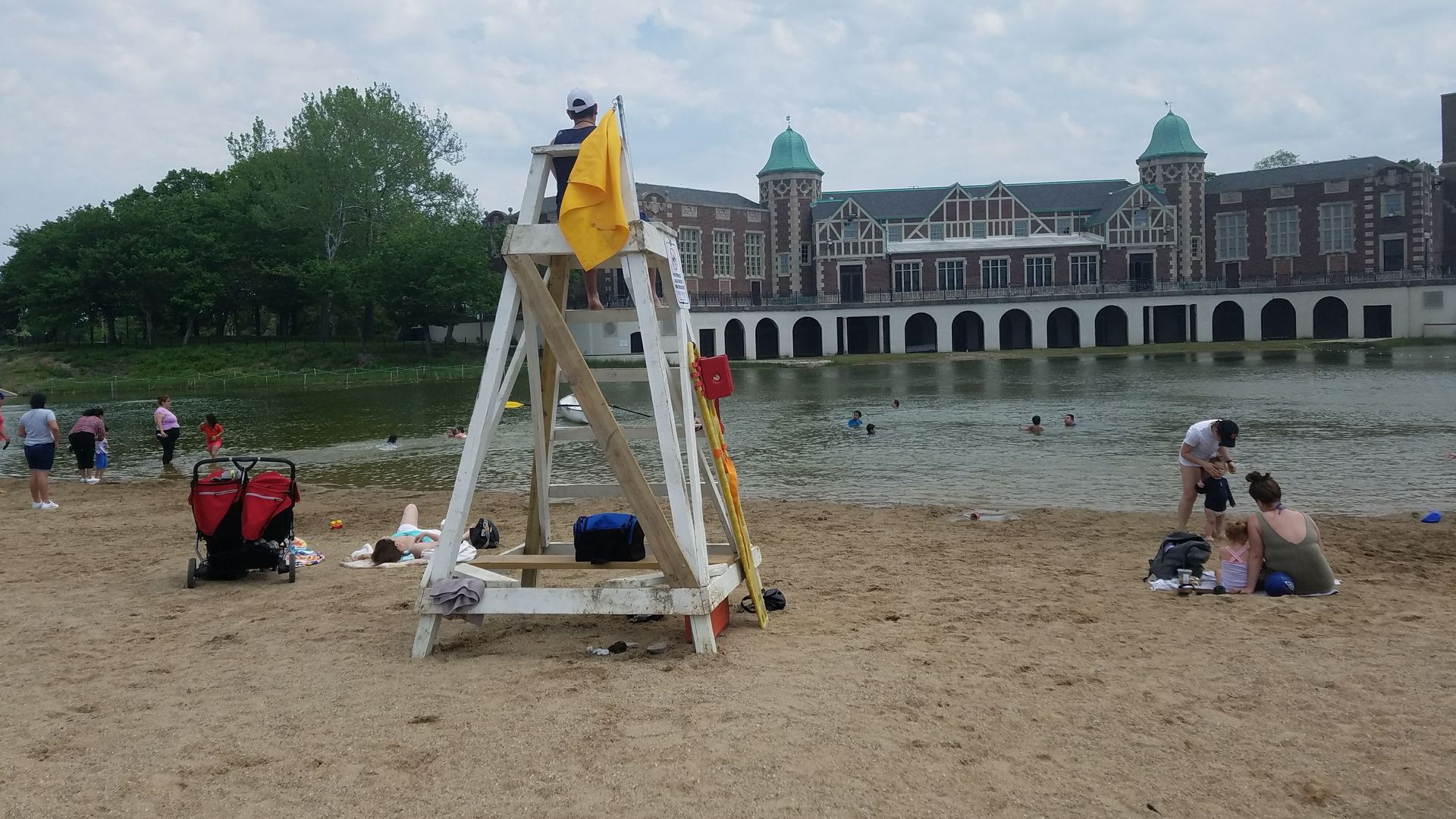 A photo of the Humboldt Park beach with people laying in sand. 