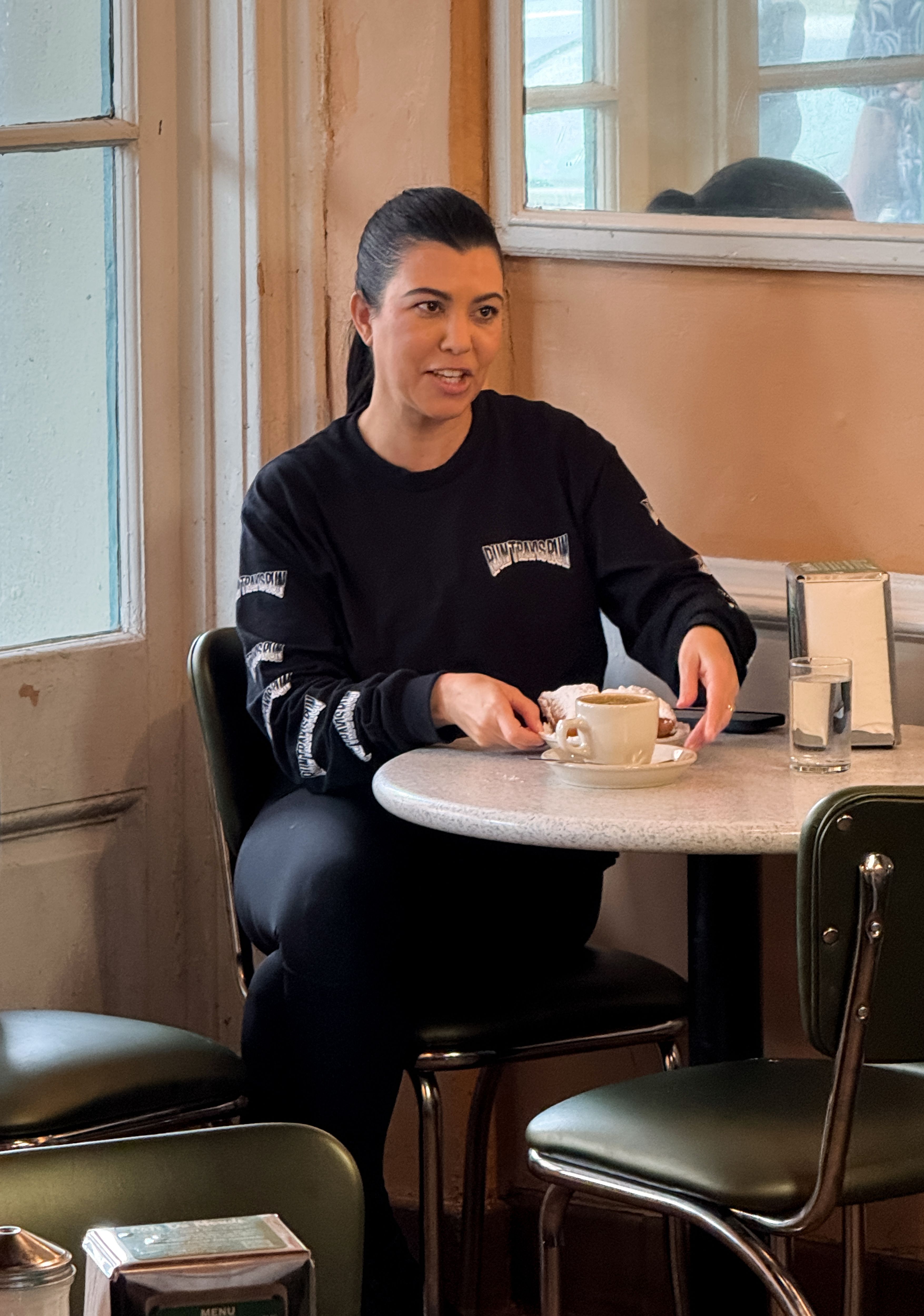 Photo shows Kourtney Kardashian with a beignet.