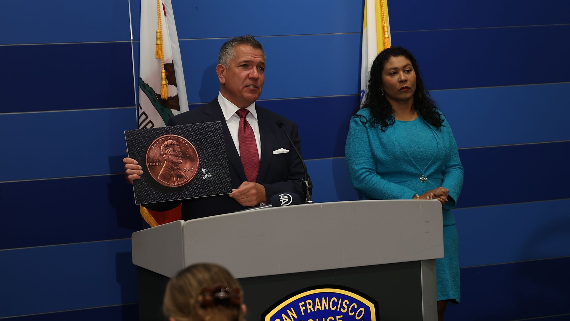 Photo of Matt Dorsey and London Breed speaking from a podium 