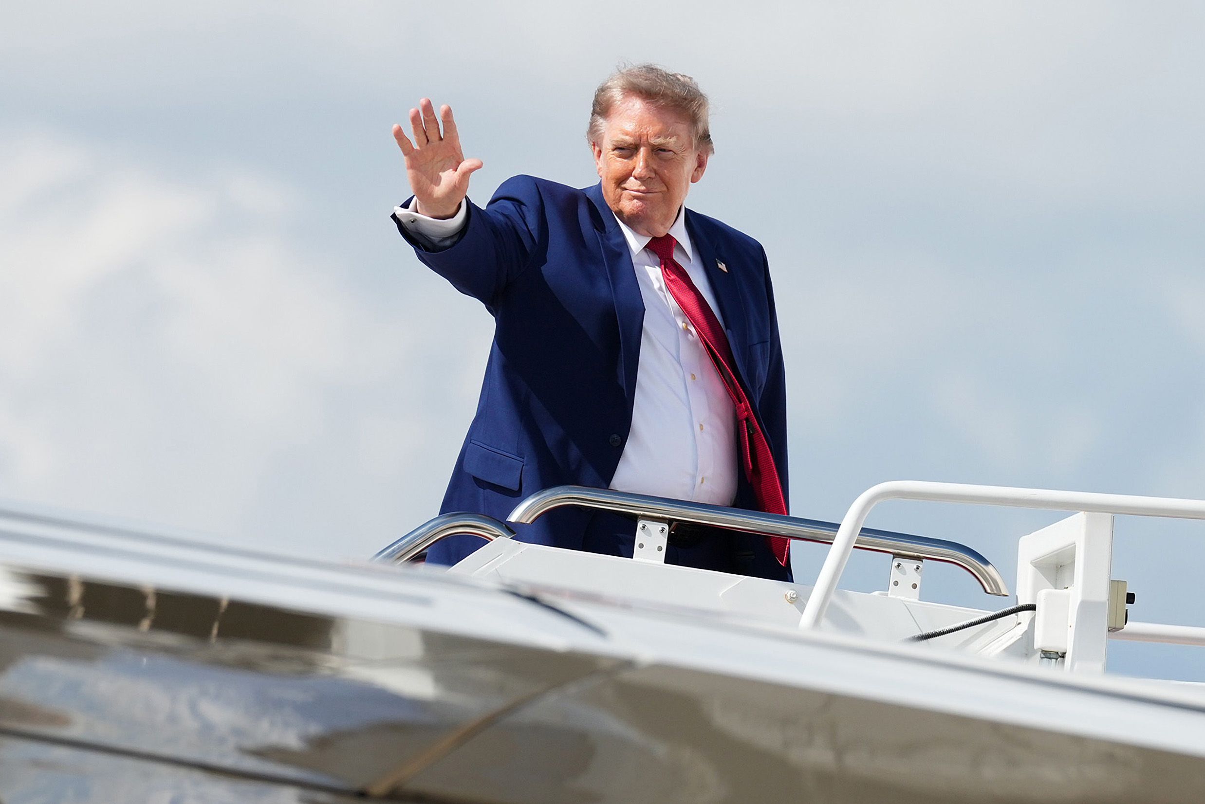 Trump waves as he boards Air Force One