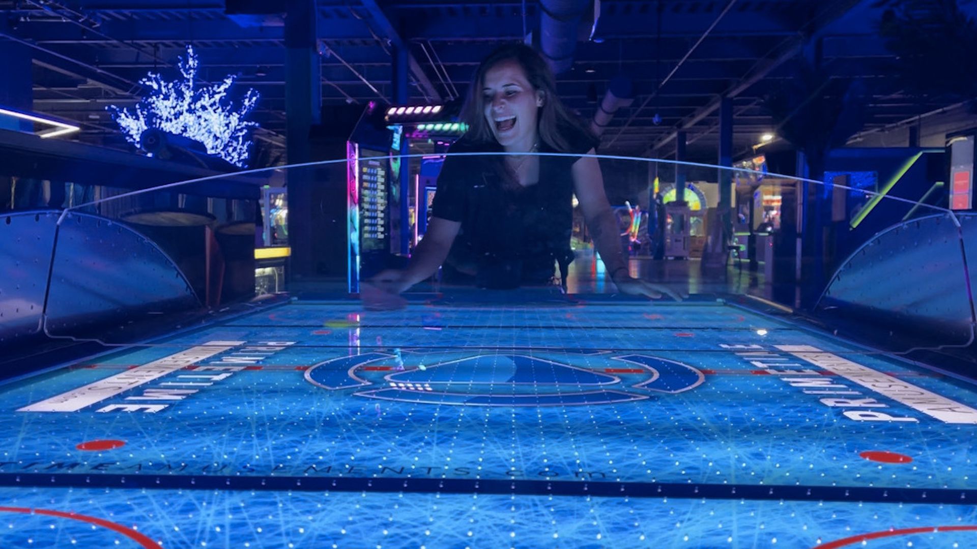 A very pretty girl playing air hockey