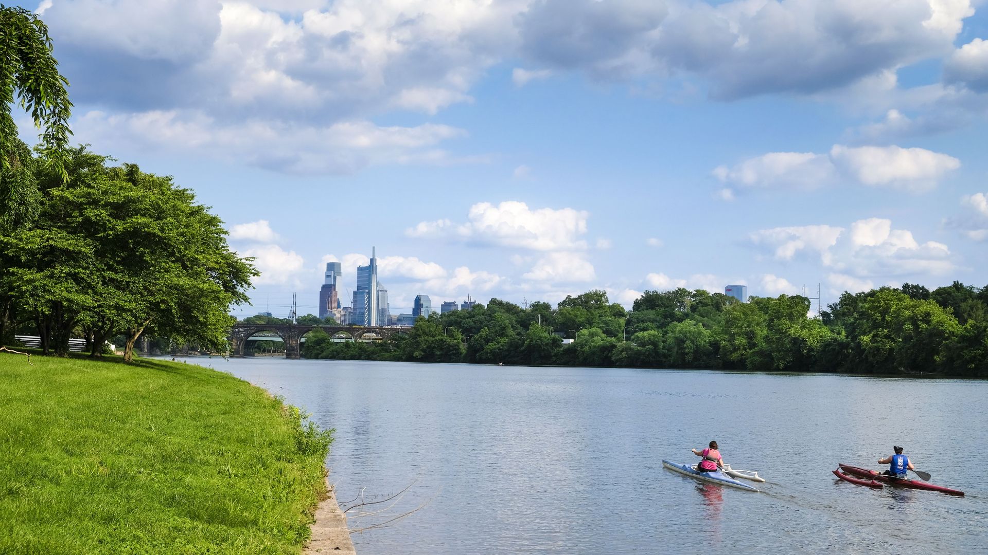 People kayak in front of the Philly skyline