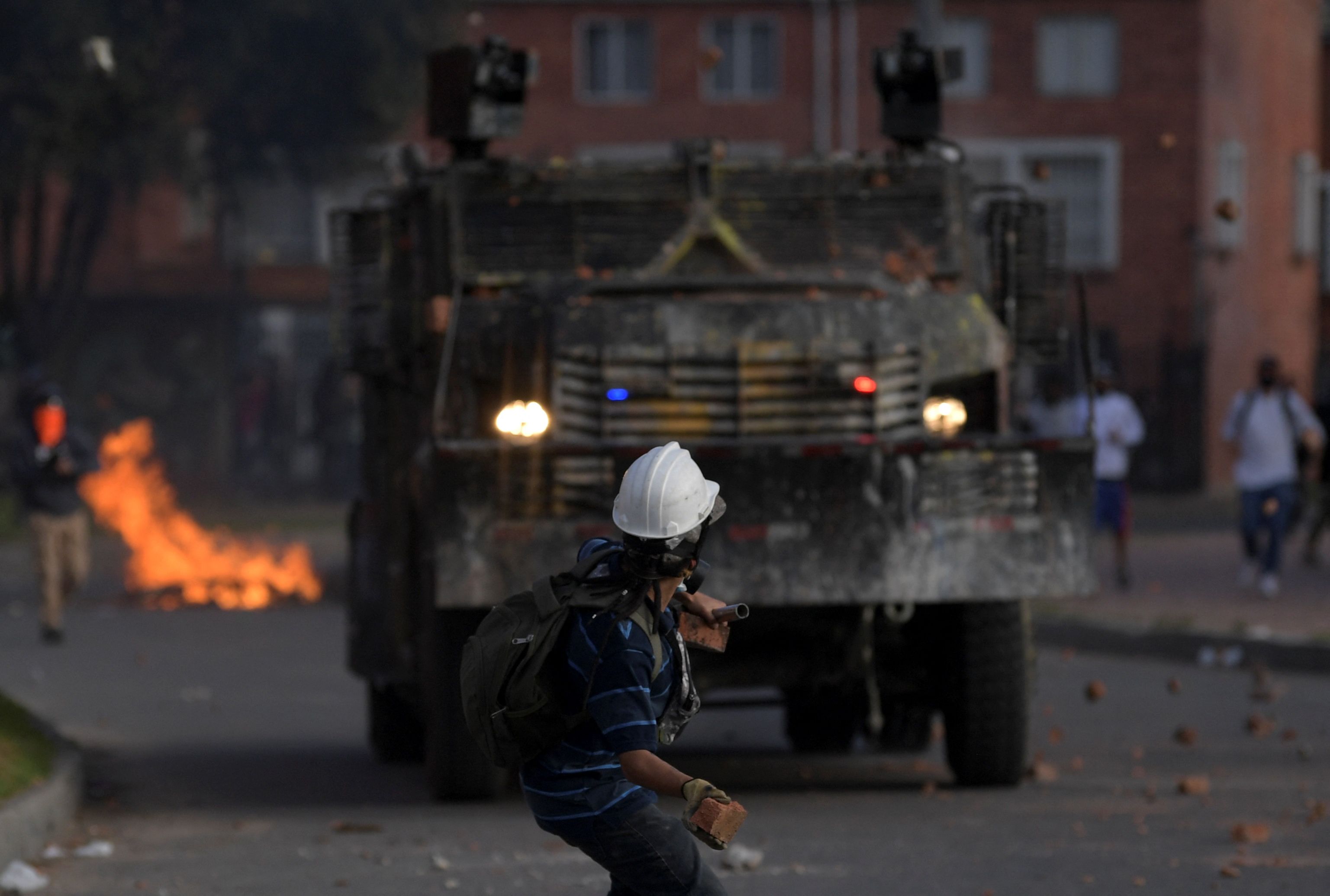 A demonstrator protesting against the government of Colombian President Ivan Duque throws a piece of brick at riot police during clashes in Suba neighbourhood, Bogota.