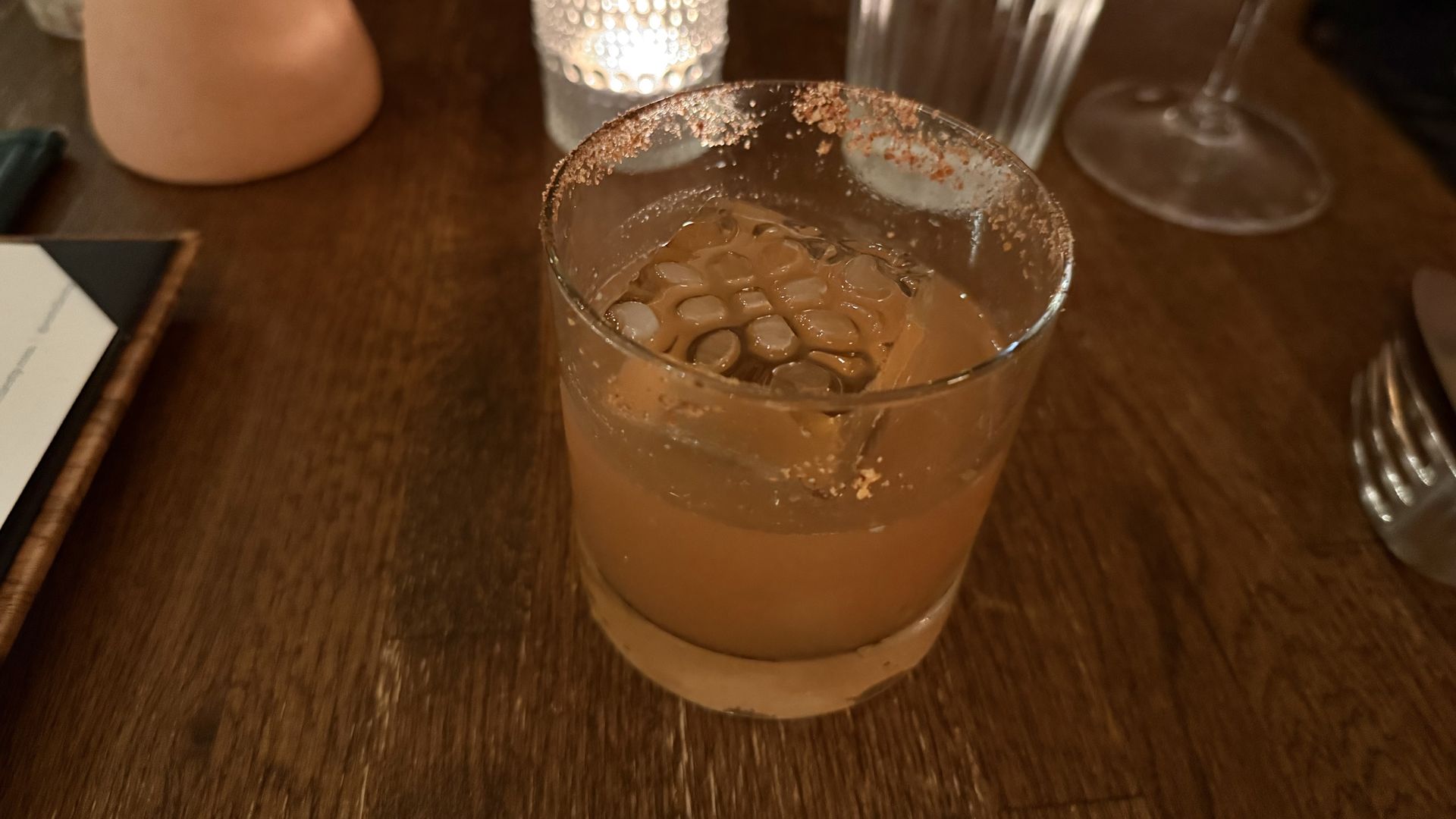 A drink that's orange in a tumbler glass